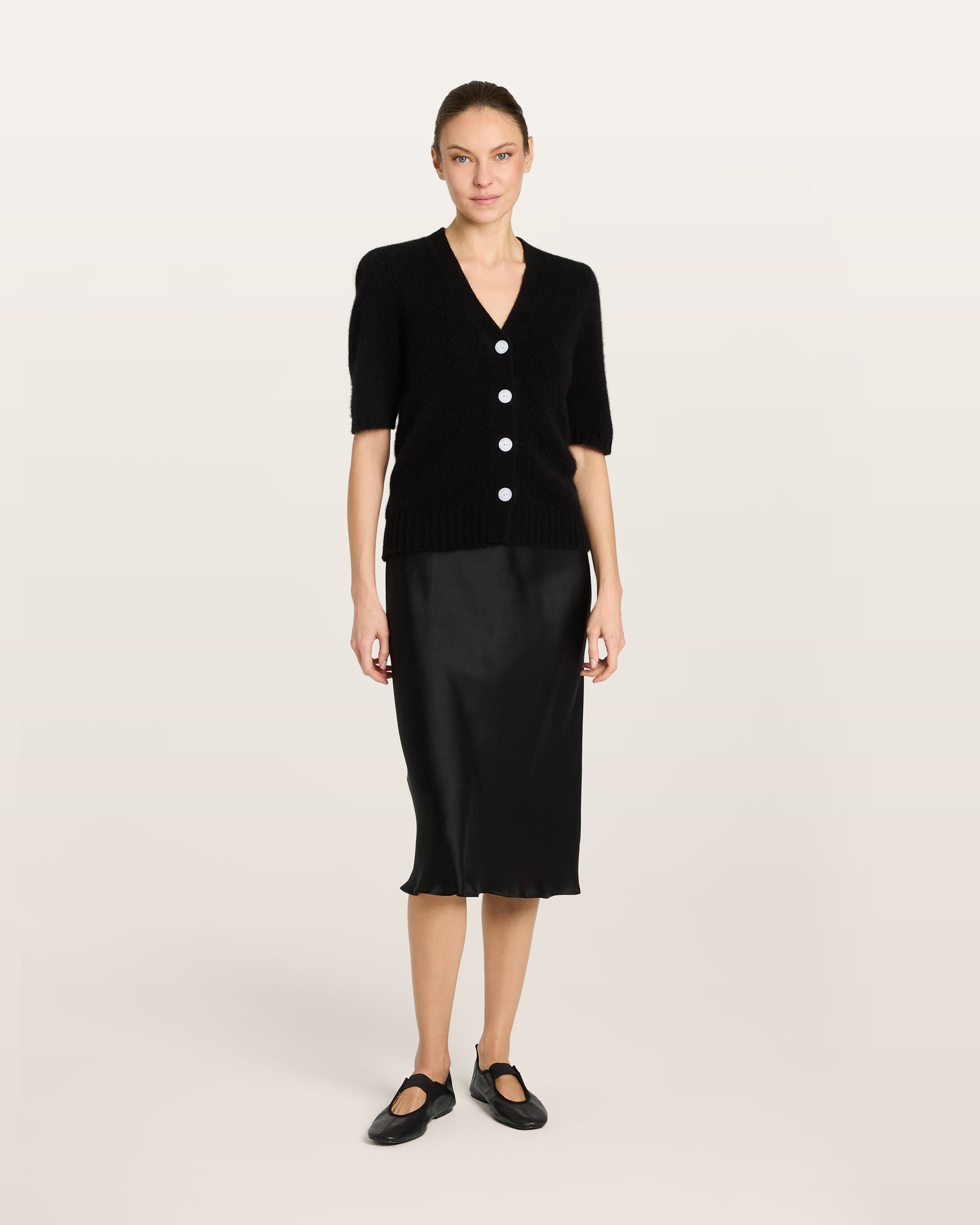 Damen Kurzarm-Jacket aus 75 % Kaschmir und 25 % Seide in black (schwarz) – mittelschwerer, glatt gestrickter Style in körperbetonter Passform mit Knopfleiste aus Kunststoff, klassischer Schulter, leichten Puff-Halbärmeln sowie Rippbündchen und hohem Ripp-Saum