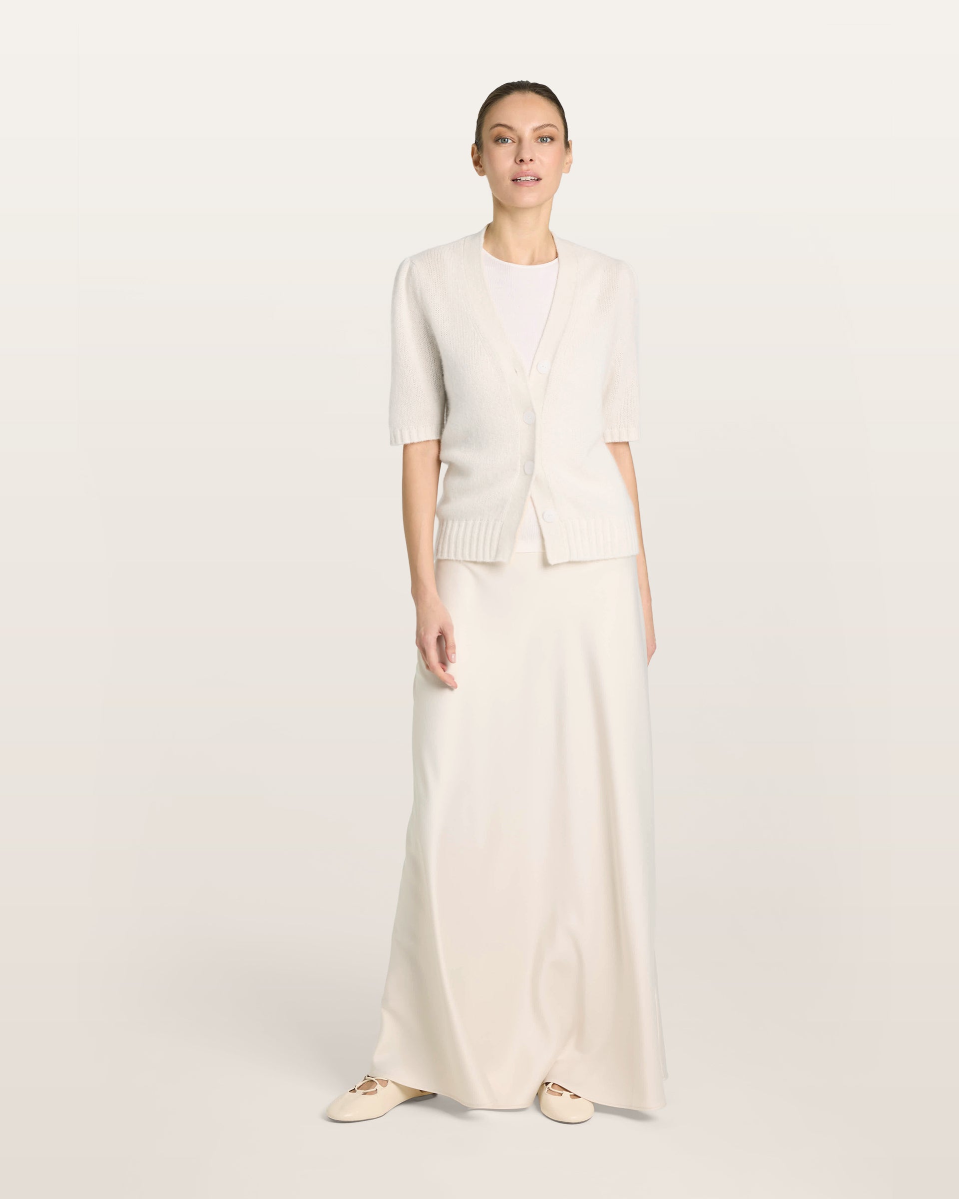 Damen Kurzarm-Jacket aus 75 % Kaschmir und 25 % Seide in ivory (cremeweiß) – mittelschwerer, glatt gestrickter Style in körperbetonter Passform mit Knopfleiste aus Kunststoff, klassischer Schulter, leichten Puff-Halbärmeln sowie Rippbündchen und hohem Ripp-Saum