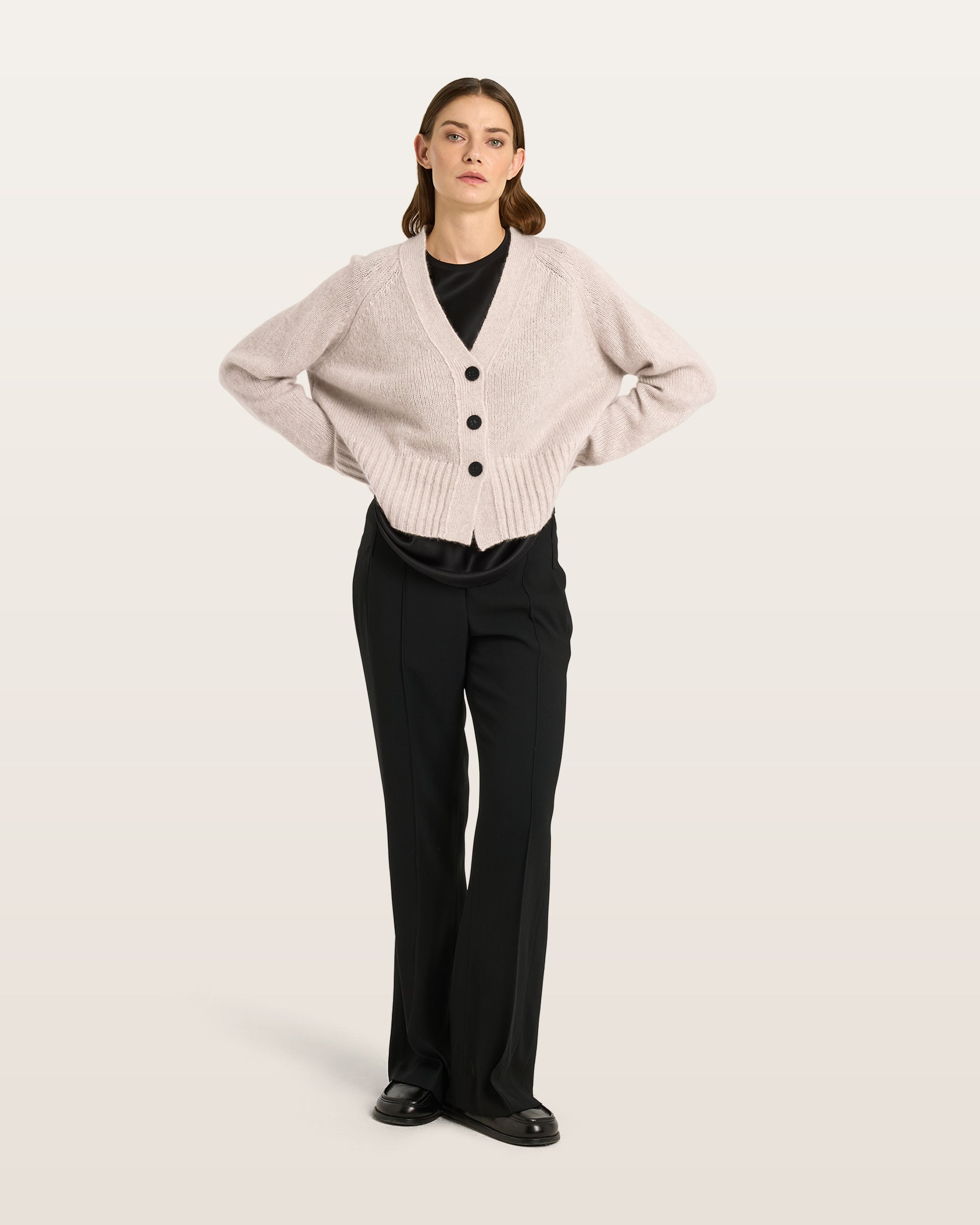 Damen Cardigan aus 75 % Kaschmir und 25 % Seide in Wheat – glatt gestrickter Cardigan in mittelschwerer Qualität mit oversized Form in breiter, kurzer Silhouette. Das Modell verfügt über Raglanärmel, lange, relaxte Ärmel sowie Knöpfe aus waschbarem Leder. Saum und Ärmelbündchen sind in Rippstruktur gearbeitet und verleihen dem Cardigan einen modernen, lässigen Look.