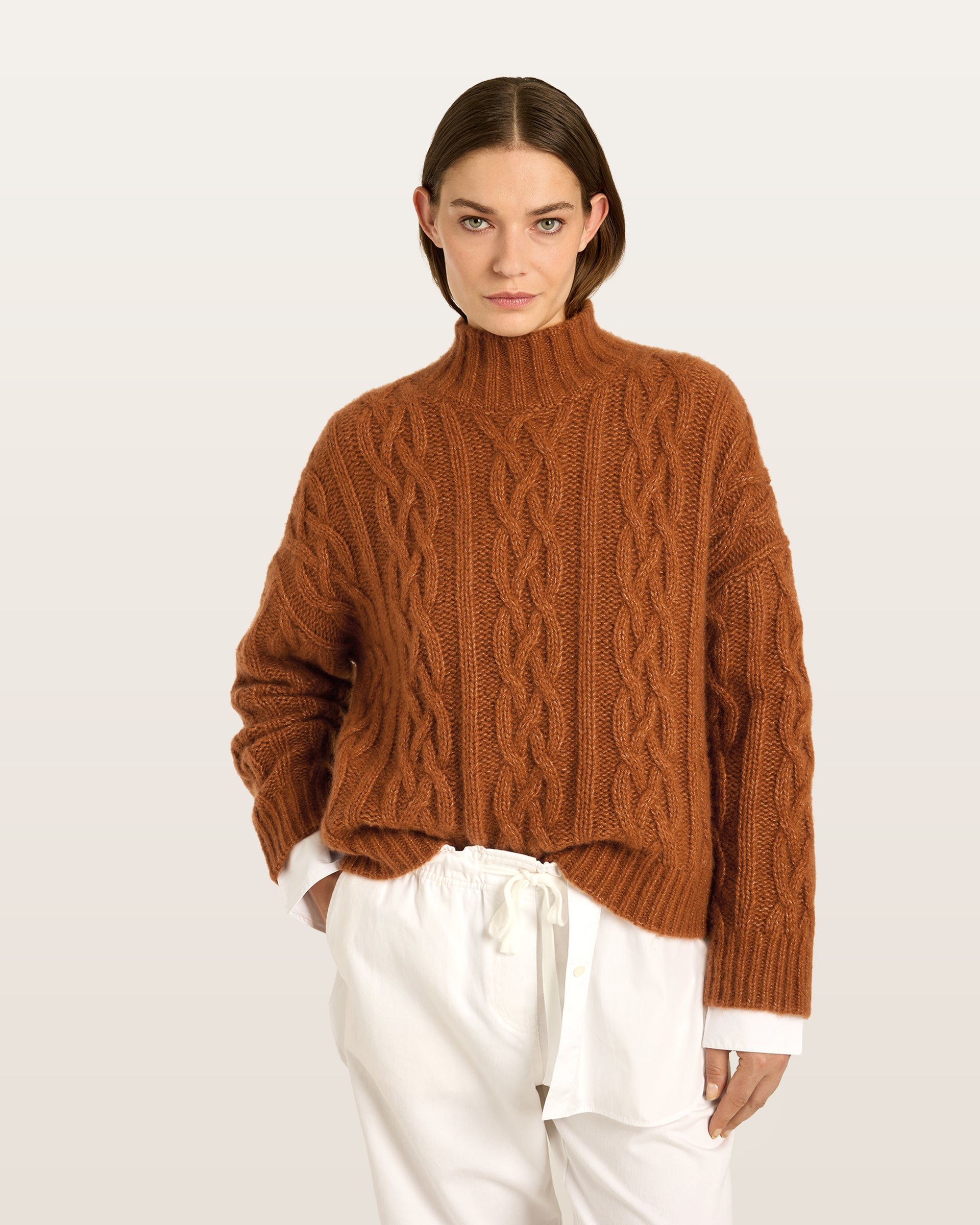 Damen Pullover aus 75 % Kaschmir und 25 % Seide in Bronze – Pullover mit Zopfmuster in grober Strickqualität und oversized Passform, Stehkragen in Rippstruktur, überschnittener Schulter sowie langen, relaxten Ärmeln. Ärmelbündchen und Saum sind in Rippstruktur gearbeitet und verleihen dem Modell einen markanten, zeitlosen Look.