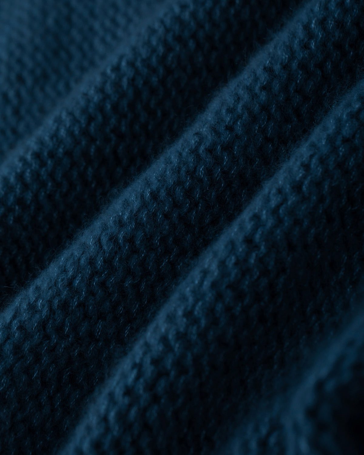 Damen Pullover aus 75 % Kaschmir und 25 % Seide in Midnight Teal – links gestrickter Pullover in grober Strickqualität mit oversized Passform. Der Rollkragen in Rippstruktur, überschnittene Schultern und lange, relaxte Ärmel verleihen dem Modell eine lässige Silhouette. Rippstrukturen an Seitennähten, Schultern und Ärmeln setzen besondere Akzente, während das verlängerte Rückenteil und seitliche Schlitze den modernen Look abrunden.
