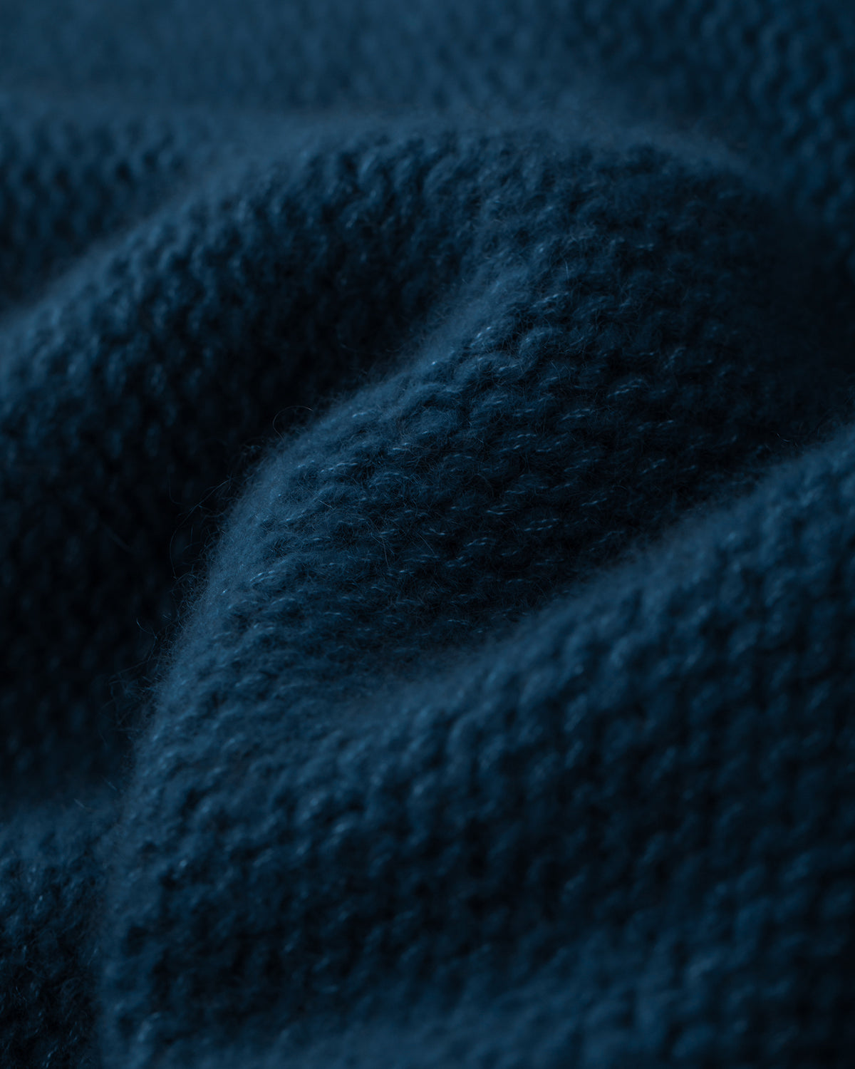 Damen Pullover aus 75 % Kaschmir und 25 % Seide in Midnight Teal – links gestrickter Pullover in grober Strickqualität mit oversized Passform. Der Rollkragen in Rippstruktur, überschnittene Schultern und lange, relaxte Ärmel verleihen dem Modell eine lässige Silhouette. Rippstrukturen an Seitennähten, Schultern und Ärmeln setzen besondere Akzente, während das verlängerte Rückenteil und seitliche Schlitze den modernen Look abrunden.