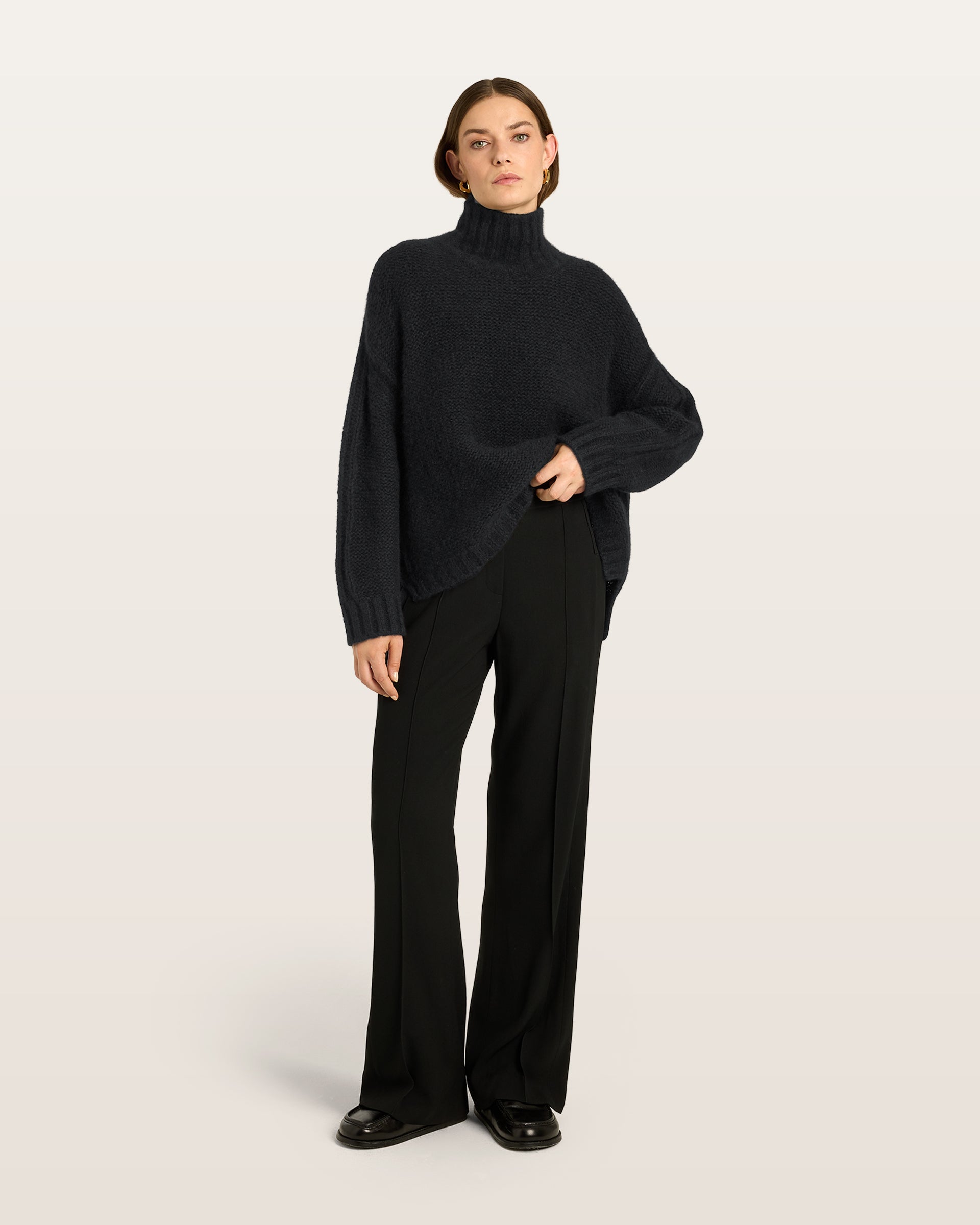 Damen Pullover aus 75 % Kaschmir und 25 % Seide in Black – links gestrickter Pullover in grober Strickqualität mit oversized Passform. Der Rollkragen in Rippstruktur, überschnittene Schultern und lange, relaxte Ärmel verleihen dem Modell eine lässige Silhouette. Rippstrukturen an Seitennähten, Schultern und Ärmeln setzen besondere Akzente, während das verlängerte Rückenteil und seitliche Schlitze den modernen Look abrunden.