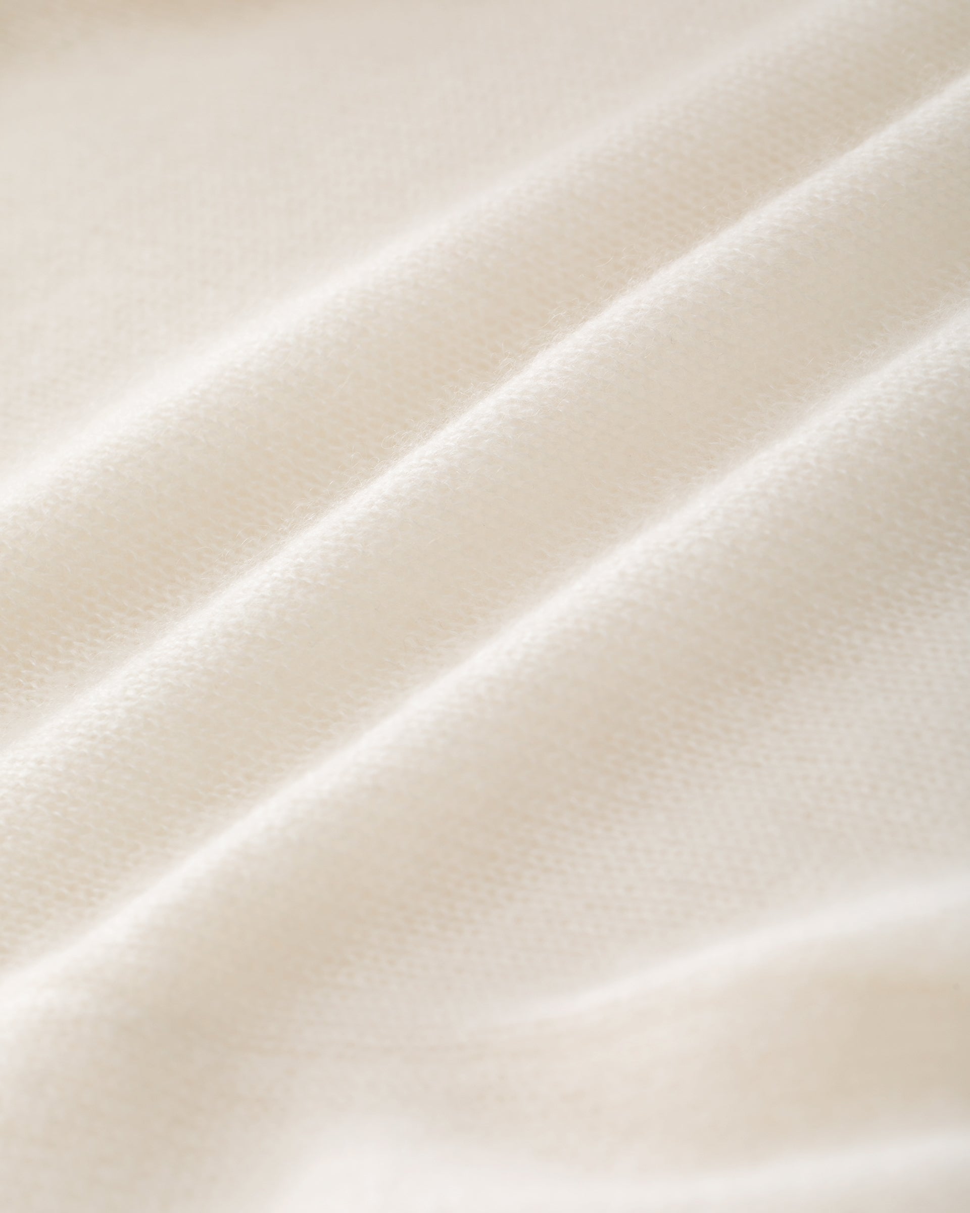 Damen Strickmantel in ivory (cremeweiß) aus Kaschmir-Seide – glatt und leicht gestrickt, relaxte Passform, überschnittene Schultern, lange relaxte Ärmel mit Rippbündchen, Saum in Rippstruktur und langer Gürtel.