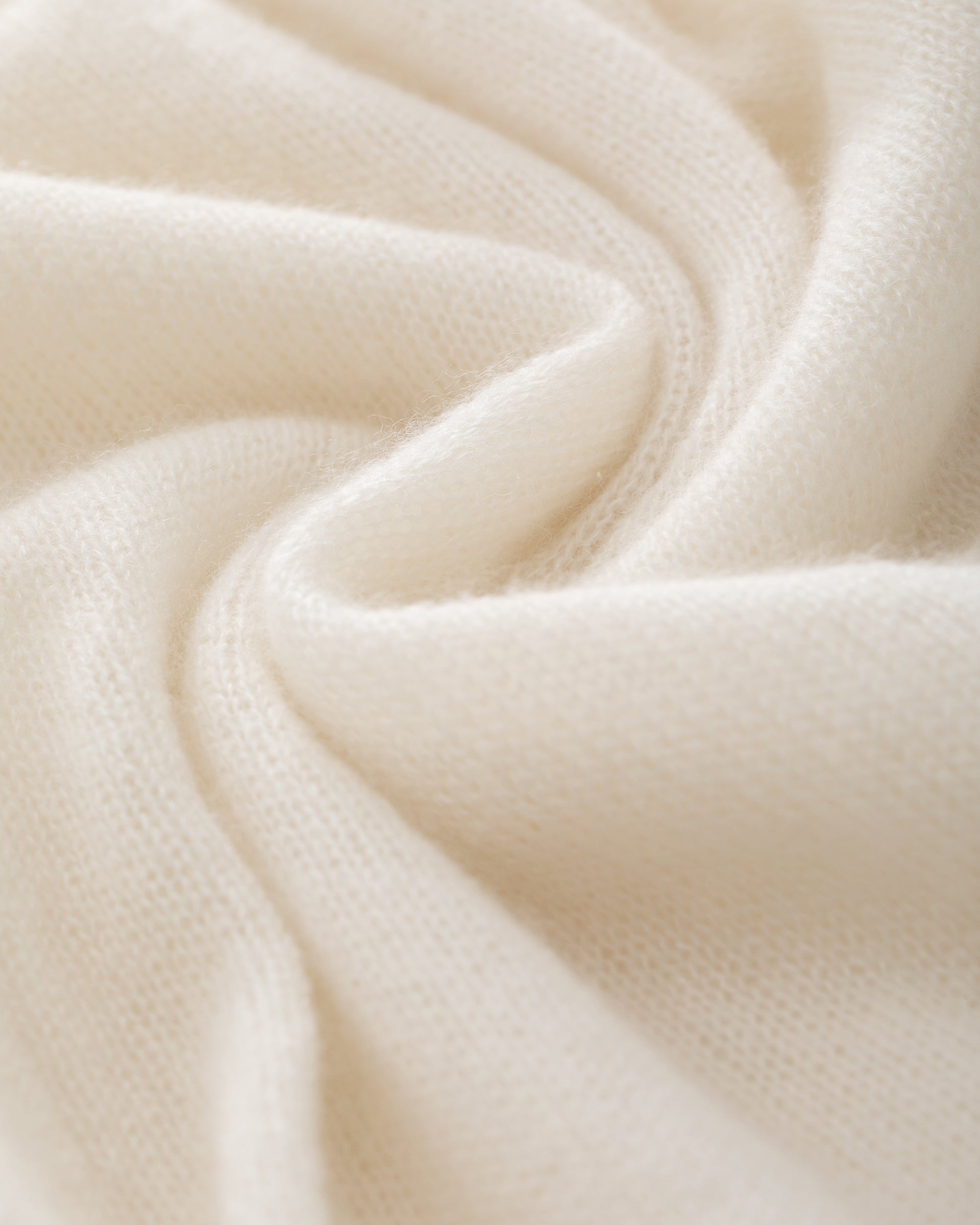 Damen Strickmantel in ivory (cremeweiß) aus Kaschmir-Seide – glatt und leicht gestrickt, relaxte Passform, überschnittene Schultern, lange relaxte Ärmel mit Rippbündchen, Saum in Rippstruktur und langer Gürtel.