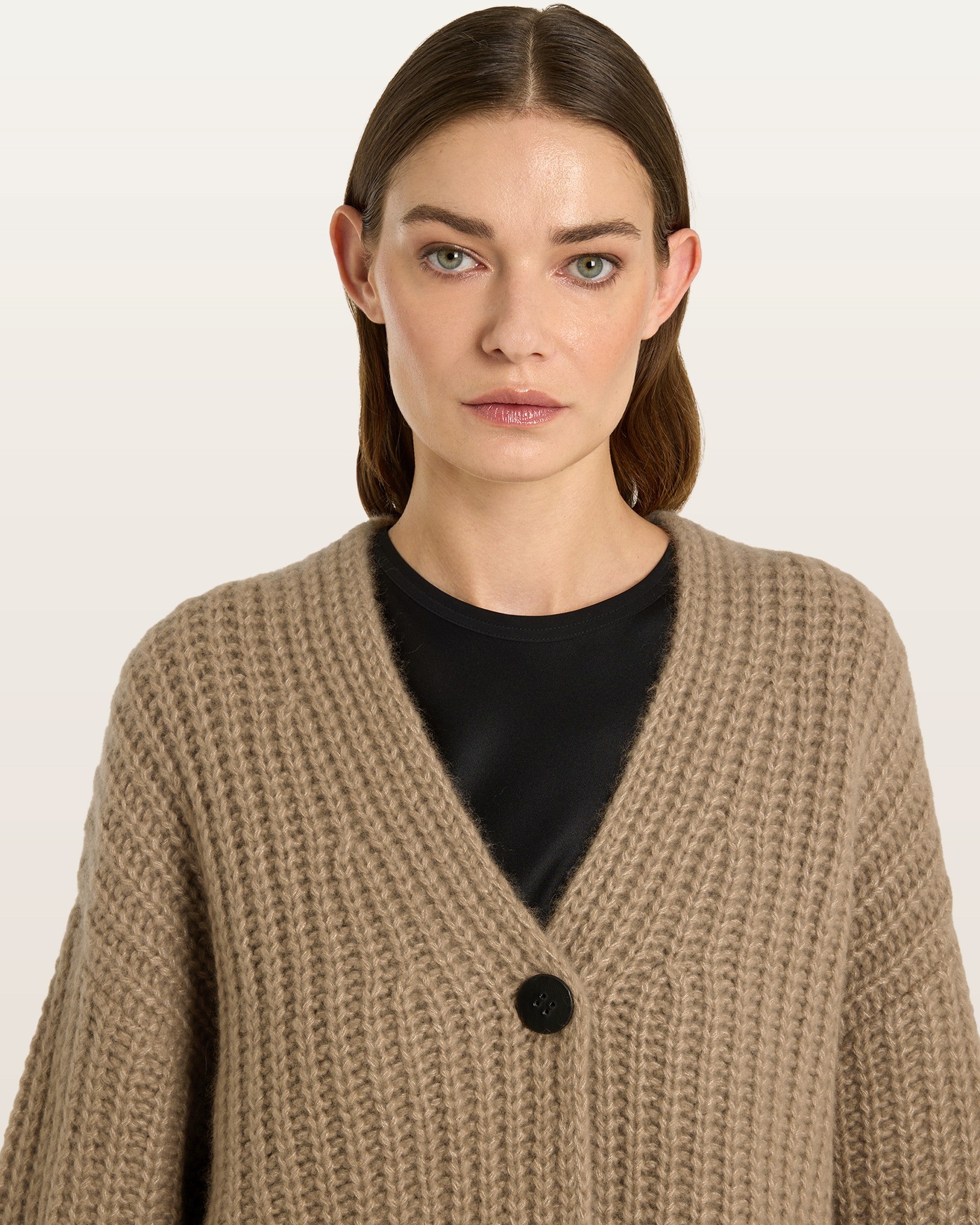 Damen Cardigan aus 75 % Kaschmir und 25 % Seide in Warm Sand – im Halbpatent-Strickmuster gearbeiteter Cardigan in grober Strickqualität mit oversized Passform in kurzer, weiter Silhouette. Das Modell verfügt über eine überschnittene Schulter, lange, weite Ärmel sowie einen einzelnen Knopf aus waschbarem Leder als Verschlussdetail.