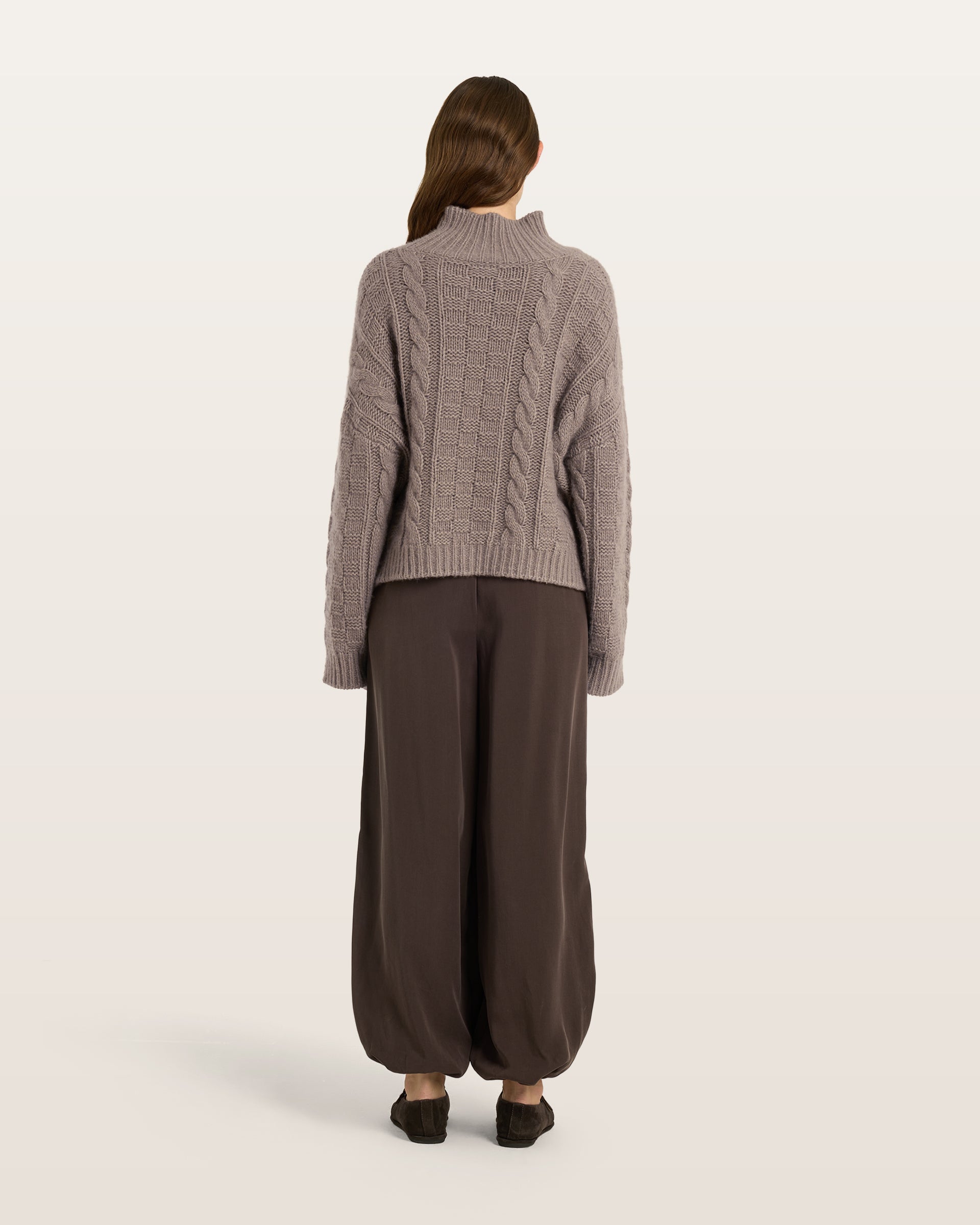 Damen Pullover aus 75 % Kaschmir und 25 % Seide in Natural Twine – grob gestrickter Pullover mit Zopf- und Schachbrettmuster in oversized Passform, hohem Stehkragen in Rippstruktur, überschnittener Schulter sowie langen, relaxten Ärmeln. Ärmelbündchen und Saum sind in Rippstruktur gearbeitet und unterstreichen den markanten Strickcharakter des Modells.
