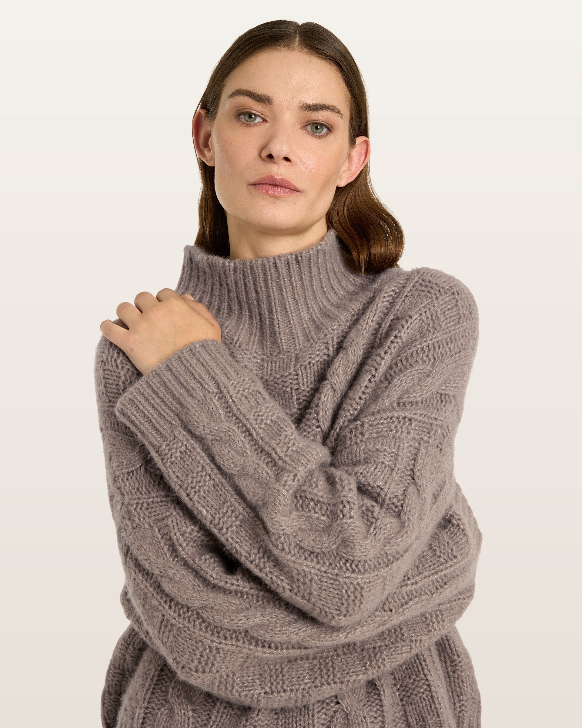 Damen Pullover aus 75 % Kaschmir und 25 % Seide in Natural Twine – grob gestrickter Pullover mit Zopf- und Schachbrettmuster in oversized Passform, hohem Stehkragen in Rippstruktur, überschnittener Schulter sowie langen, relaxten Ärmeln. Ärmelbündchen und Saum sind in Rippstruktur gearbeitet und unterstreichen den markanten Strickcharakter des Modells.