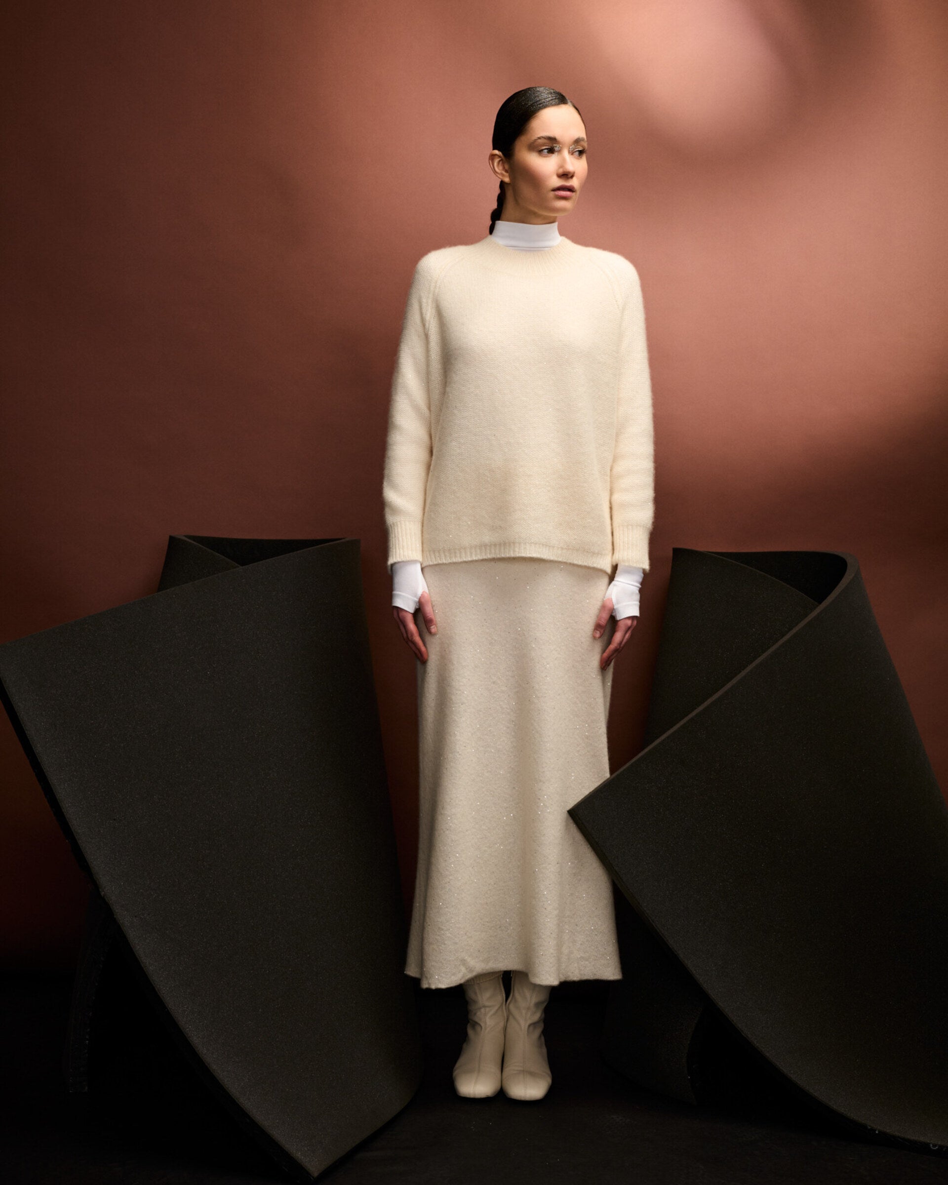 Damen Pullover aus 60 % Kaschmir, 39 % Seide und 1 % Pailletten in Ivory – links gestrickter Pullover in mittelschwerer Qualität mit lockerer Passform und geradem Schnitt. Das lange Modell verfügt über einen Rundhalsausschnitt mit hohem Kragen in Rippstruktur, Raglanärmel sowie lange, relaxte Ärmel. Ärmelbündchen und Saum sind in Rippstruktur gearbeitet. Schlitze an den Seitennähten und dezent eingearbeitete Pailletten verleihen dem Pullover eine moderne, elegante Ausstrahlung.