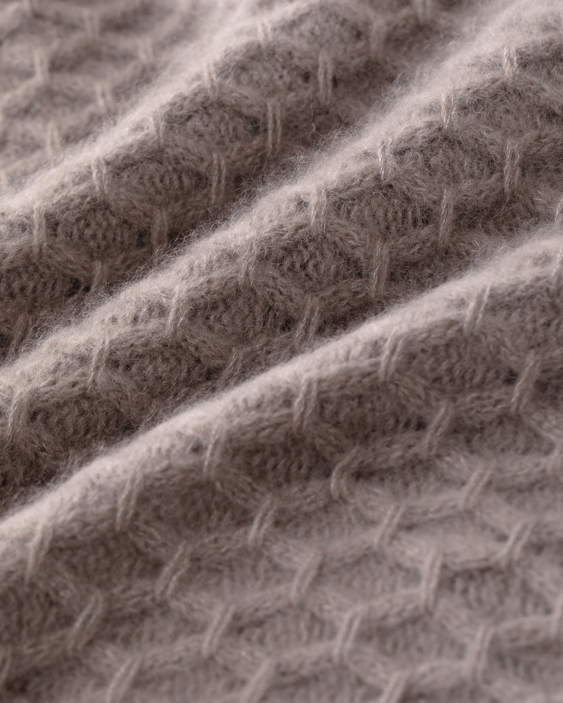 Damen Pullover aus 75 % Kaschmir und 25 % Seide in Natural Twine – Pullover mit grafischem Zopfstrickmuster in grober Strickqualität und oversized Passform mit breiter, kurzer, gerade geschnittener Silhouette. Das Modell verfügt über einen Rundhalsausschnitt mit Kragen in Rippstruktur, Raglanärmel sowie lange, relaxte Ärmel. Hohe Ärmelbündchen und Saum sind in Rippstruktur gearbeitet und verleihen dem Design einen markanten, modernen Look.