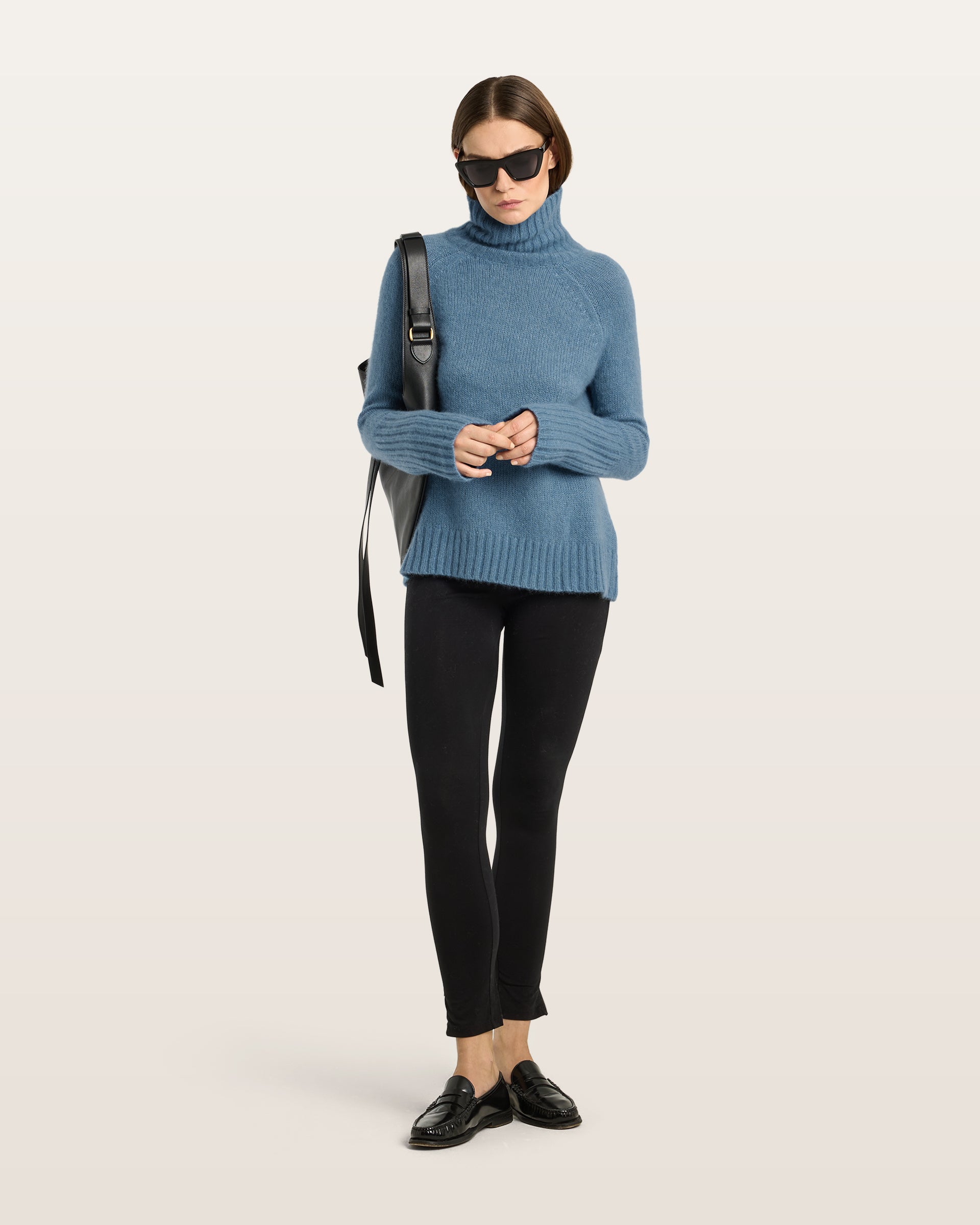 Damen Pullover aus 75 % Kaschmir und 25 % Seide in Blue Fog – glatt gestrickter Pullover in mittelschwerer Qualität mit langer, relaxter Passform, die zum Saum hin leicht ausgestellt ist. Das Modell verfügt über einen Stehkragen in Rippstruktur, Raglanschultern sowie lange, schmale Ärmel. Hohe Ärmelbündchen und der Saum sind in Rippstruktur gearbeitet und verleihen dem Pullover eine moderne, elegante Silhouette.