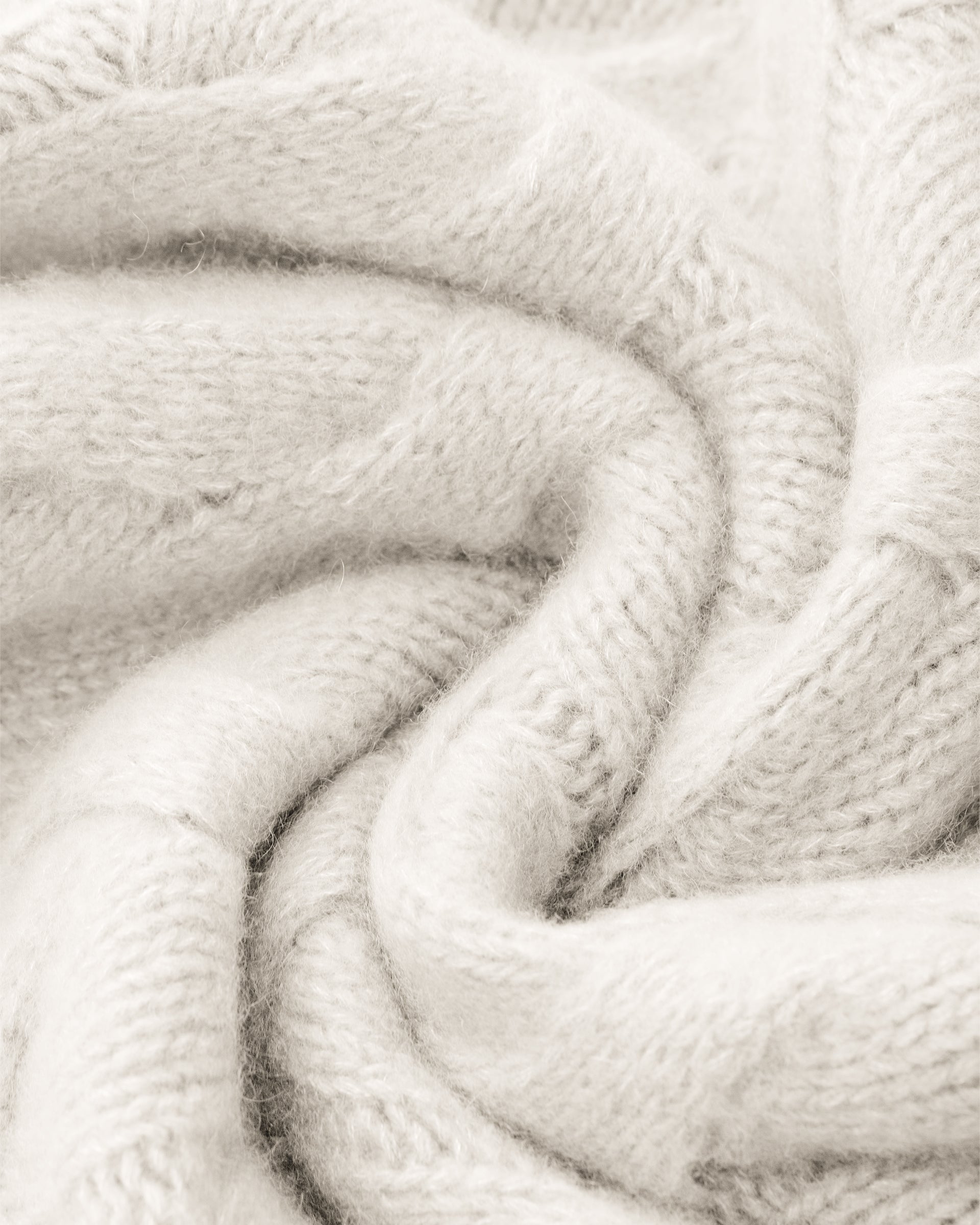 Damen Pullover aus 75 % Kaschmir und 25 % Seide in Ivory – grob gestrickter Pullover mit Zopfstrickmuster in oversized Passform mit langer, weiter Silhouette. Das Modell verfügt über einen hohen Stehkragen in Rippstruktur, eine überschnittene Schulter sowie lange, weite Ärmel. Ärmelbündchen und Saum sind in Rippstruktur gearbeitet und unterstreichen den markanten Strickcharakter des Designs.