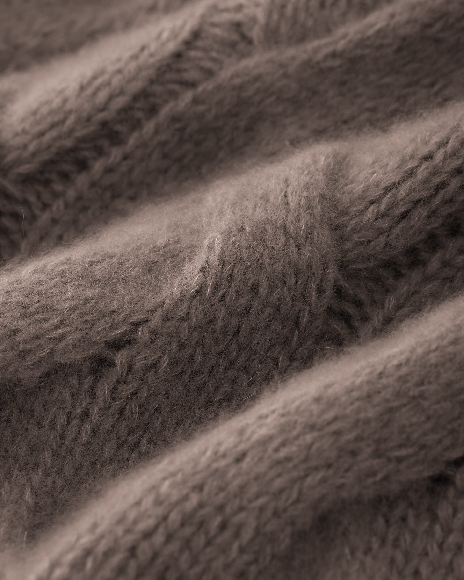 Damen Pullover aus 75 % Kaschmir und 25 % Seide in Natural Twine – grob gestrickter Pullover mit Zopfstrickmuster in oversized Passform mit langer, weiter Silhouette. Das Modell verfügt über einen hohen Stehkragen in Rippstruktur, eine überschnittene Schulter sowie lange, weite Ärmel. Ärmelbündchen und Saum sind in Rippstruktur gearbeitet und unterstreichen den markanten Strickcharakter des Designs.