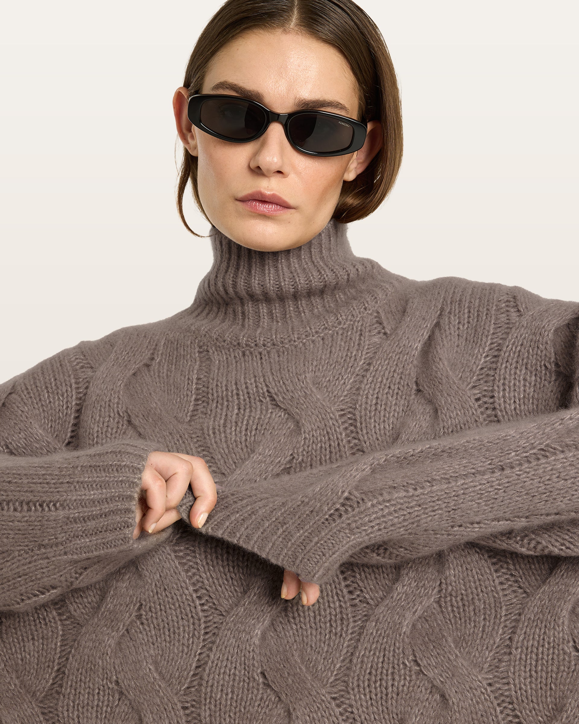 Damen Pullover aus 75 % Kaschmir und 25 % Seide in Natural Twine – grob gestrickter Pullover mit Zopfstrickmuster in oversized Passform mit langer, weiter Silhouette. Das Modell verfügt über einen hohen Stehkragen in Rippstruktur, eine überschnittene Schulter sowie lange, weite Ärmel. Ärmelbündchen und Saum sind in Rippstruktur gearbeitet und unterstreichen den markanten Strickcharakter des Designs.