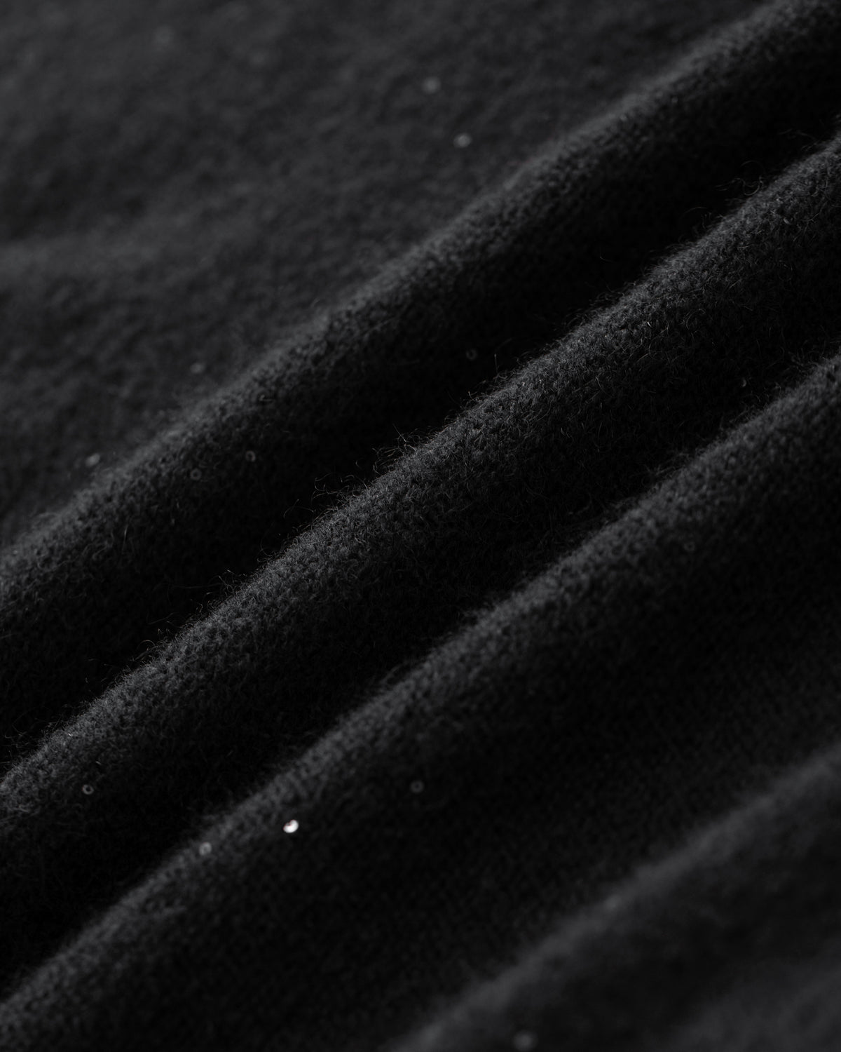 Damen Pullover aus 60 % Kaschmir, 39 % Seide und 1 % Pailletten in Black – links gestrickter Pullover in mittelschwerer Qualität mit lockerer Passform, Polokragen mit tiefer, offener Leiste, klassischer, leicht überschnittener Schulterform sowie langen, relaxten Ärmeln. Ärmelbündchen und Saum sind in Rippstruktur gearbeitet. Dezent eingearbeitete Pailletten verleihen dem Modell einen eleganten, schimmernden Akzent.