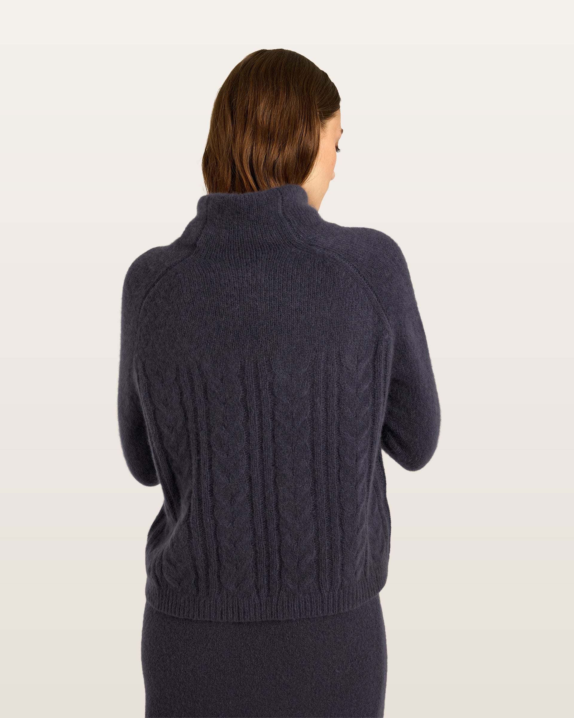 Damen Pullover aus 75 % Kaschmir und 25 % Seide in Graphite Grey – glatt gestrickter Pullover mit Zopfstrickmuster in mittelschwerer Qualität und figurbetonter Passform. Das Modell verfügt über einen Kragen, der als Stehkragen oder Rollkragen getragen werden kann, Raglanärmel sowie lange, schmale Ärmel. Ärmelbündchen und Saum sind in Rippstruktur gearbeitet und verleihen dem Design einen stilvollen Abschluss.