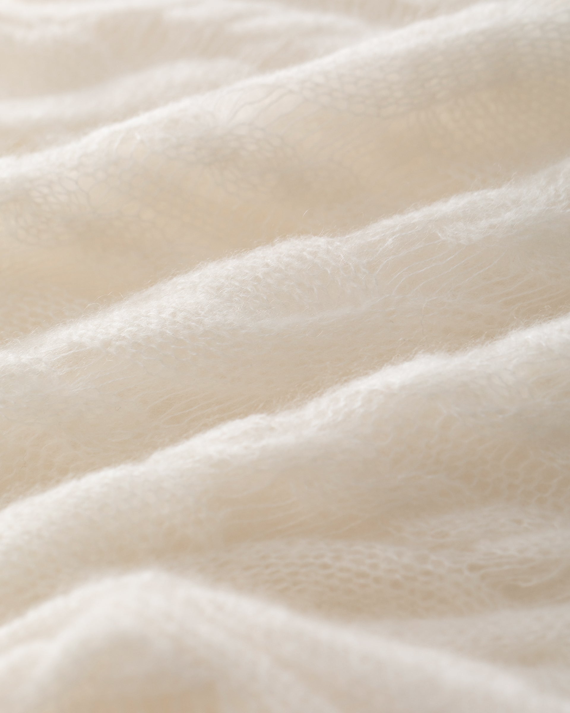 Damen Pullover in ivory (cremeweiß) aus Kaschmir-Seide – sehr filigran, leicht und luftig gestrickt, transparent mit Zopfstrickmuster und langen Flottungen, relaxte Passform, Rundhalsausschnitt mit Rippkragen, überschnittene Schultern, lange weite Ärmel sowie Rippbündchen an Ärmeln und Saum.