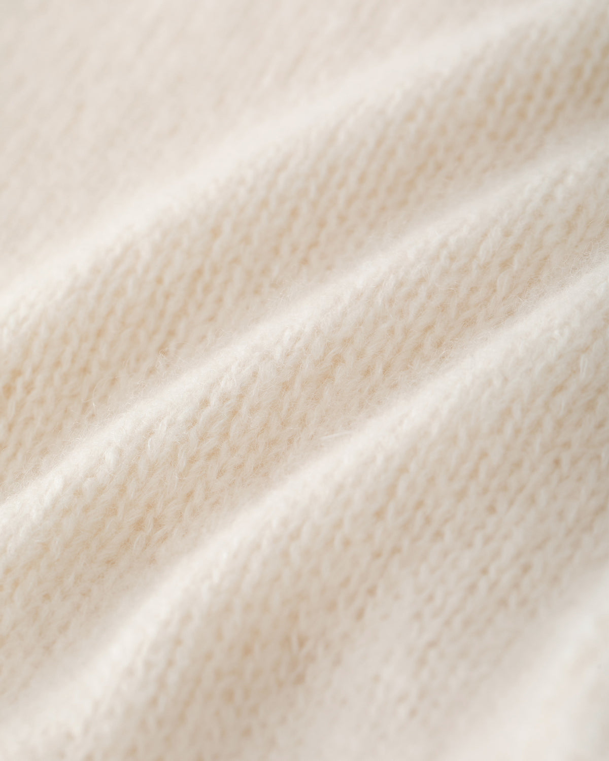 Damen Cardigan aus 75 % Kaschmir und 25 % Seide in Ivory – glatt gestrickter Cardigan in mittelschwerer Qualität mit kastiger Form in breiter, kurzer Silhouette. Das Modell verfügt über überschnittene Schultern, Hornknöpfe und lange, relaxte Ärmel. Saum und Ärmelbündchen sind in Rippstruktur gearbeitet und verleihen dem Cardigan einen modernen, lässigen Look.