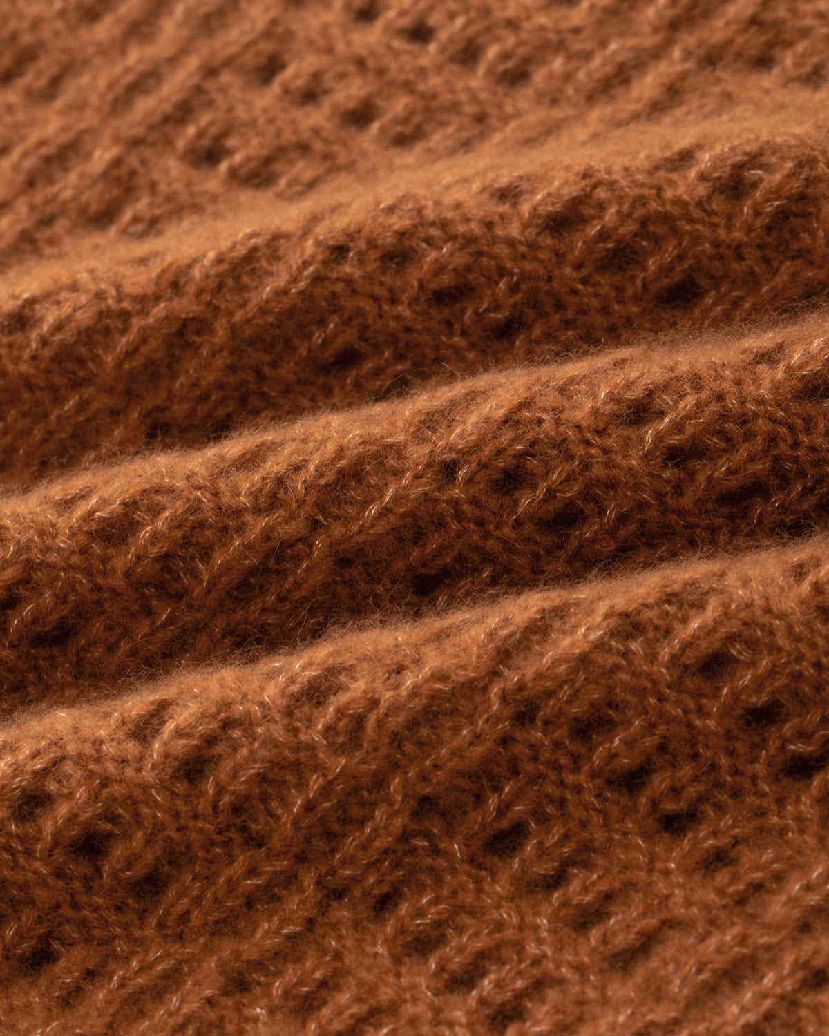 Damen Pullunder aus 75 % Kaschmir und 25 % Seide in Bronze – Pullover mit Lochstrickmuster in mittelschwerer, leicht transparenter Strickqualität und oversized Passform mit breiter, kurzer Silhouette. Das Modell verfügt über einen großen V-Ausschnitt mit Kragen in Rippstruktur. Ärmelbündchen und Saum sind in Rippstruktur gearbeitet und verleihen dem Design einen modernen, lässigen Look.