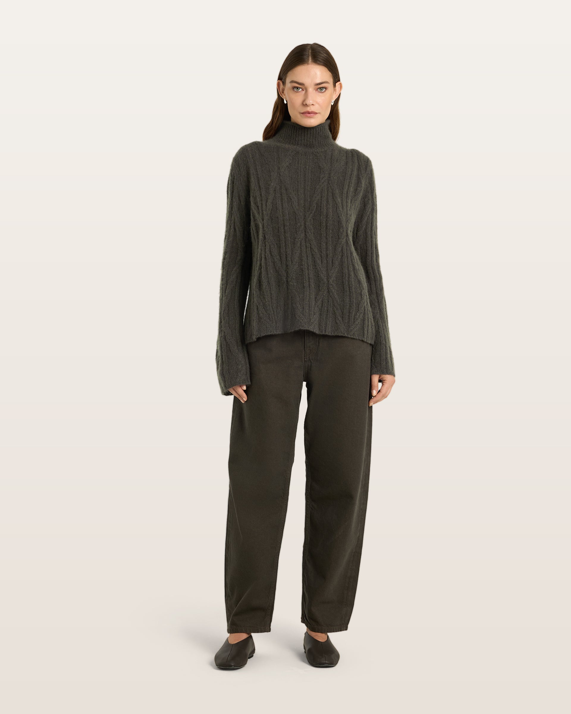 Damen Pullover aus 75 % Kaschmir und 25 % Seide in Black Forest – Pullover mit Zopfmuster in mittelschwerer Strickqualität und figurbetonter A-Linien-Passform, schmalem, hohem Kragen in Rippstruktur mit Rollkante sowie langen, relaxten Ärmeln. Das Modell verbindet markante Strickdetails mit einer femininen, leicht ausgestellten Silhouette.
