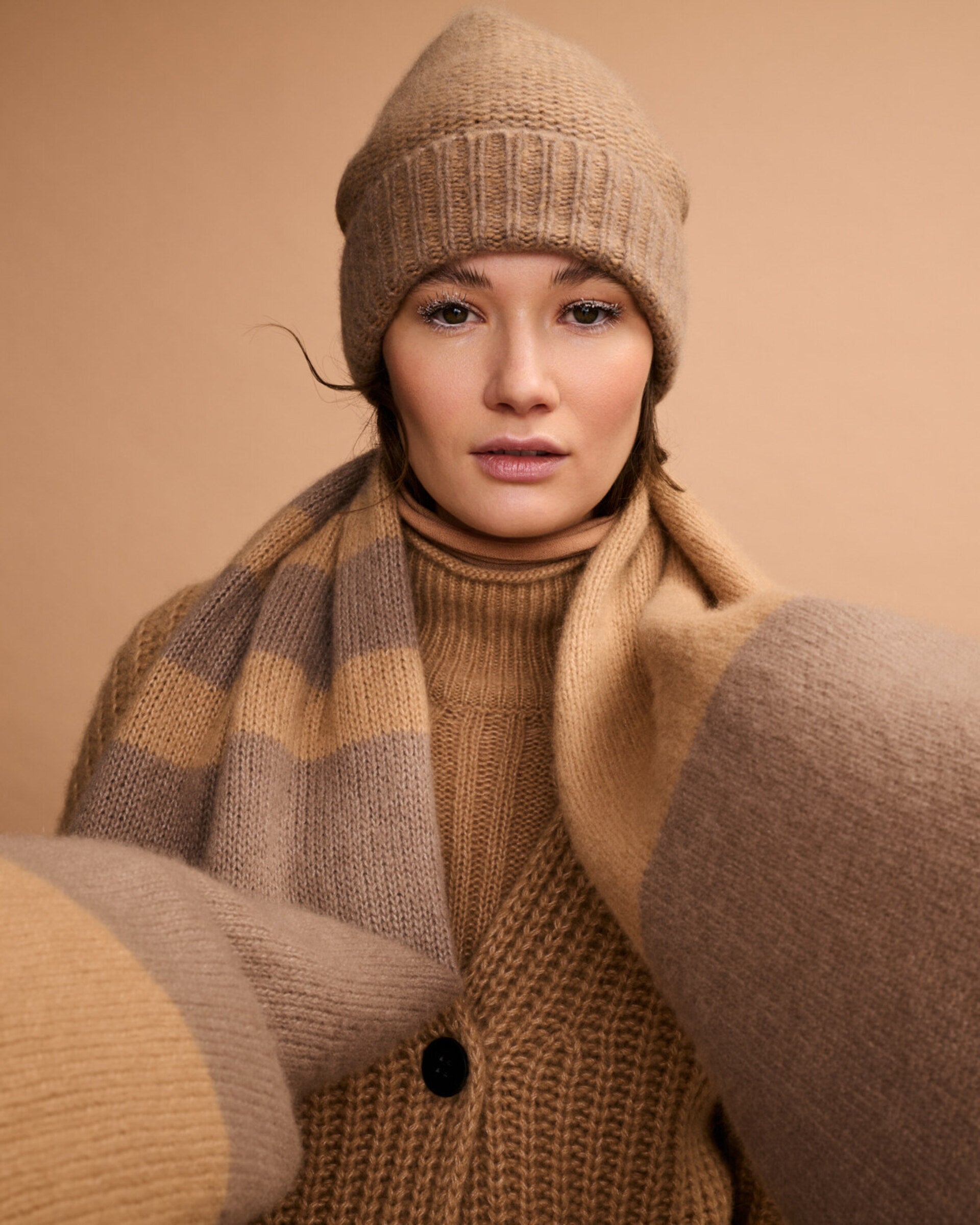Damen Pullover aus 75 % Kaschmir und 25 % Seide in Warm Sand  – Pullover mit Zopfmuster in mittelschwerer Strickqualität und figurbetonter A-Linien-Passform, schmalem, hohem Kragen in Rippstruktur mit Rollkante sowie langen, relaxten Ärmeln. Das Modell verbindet markante Strickdetails mit einer femininen, leicht ausgestellten Silhouette.
