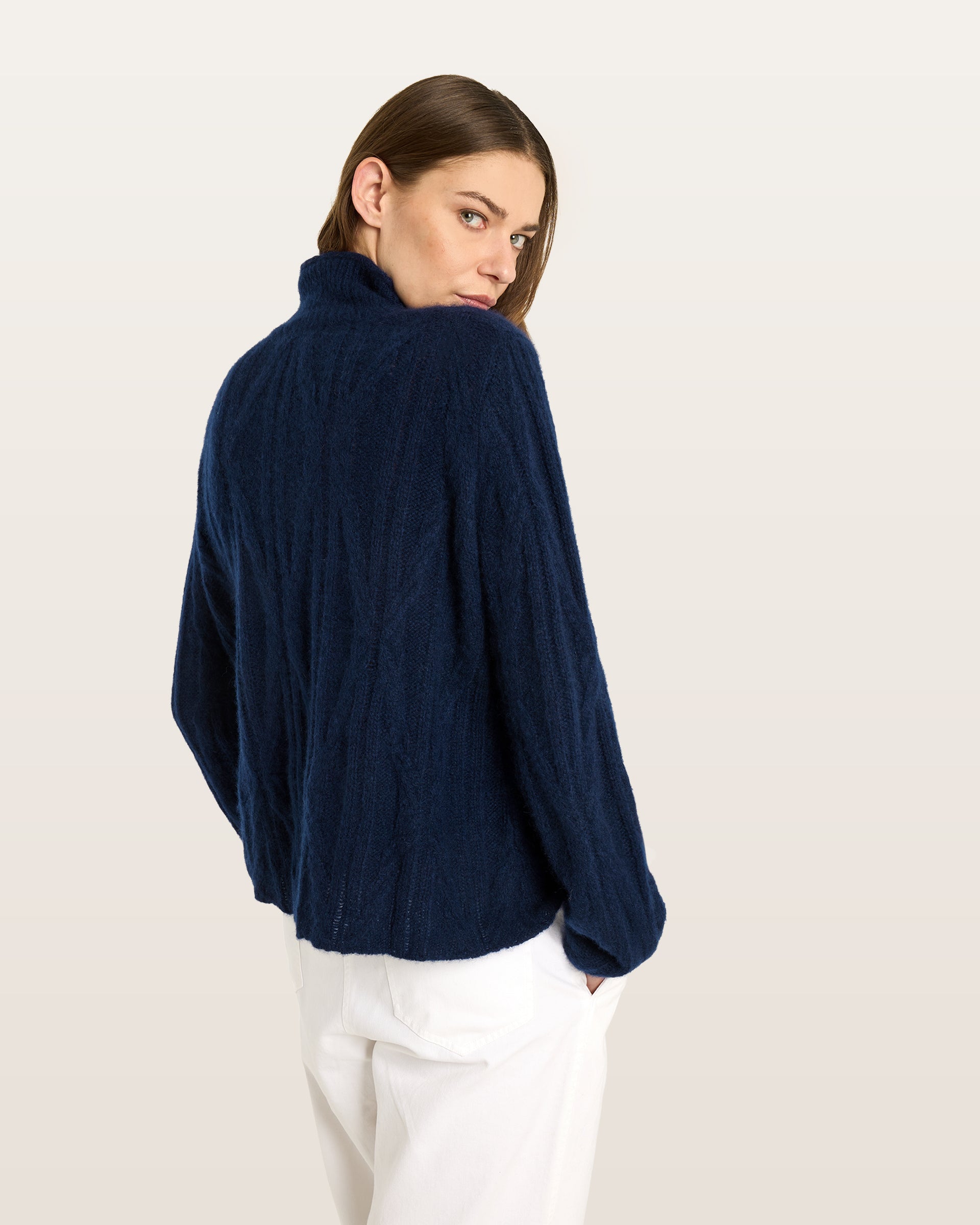 Damen Pullover aus 75 % Kaschmir und 25 % Seide in French Navy – Pullover mit Zopfmuster in mittelschwerer Strickqualität und figurbetonter A-Linien-Passform, schmalem, hohem Kragen in Rippstruktur mit Rollkante sowie langen, relaxten Ärmeln. Das Modell verbindet markante Strickdetails mit einer femininen, leicht ausgestellten Silhouette.

