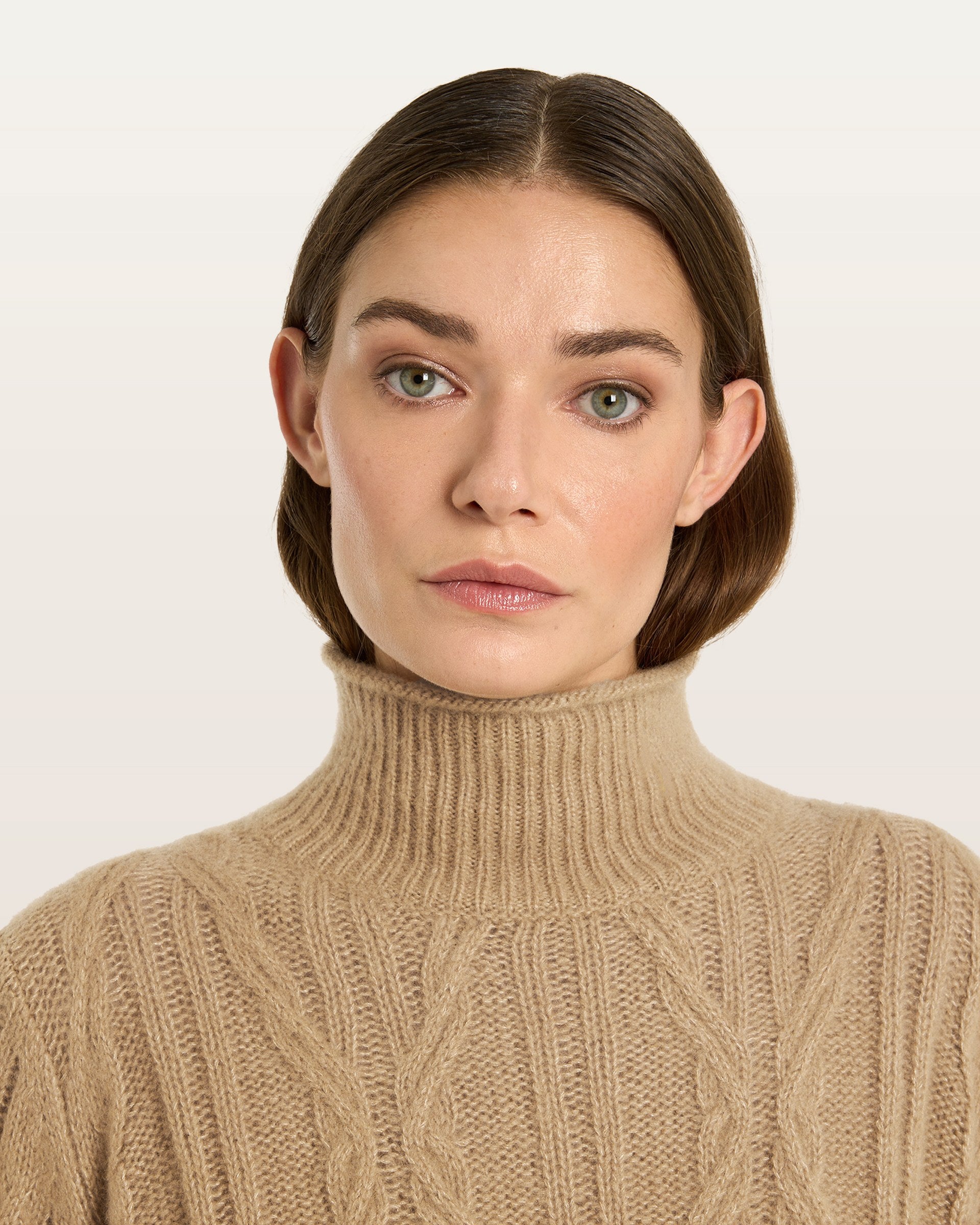 Damen Pullover aus 75 % Kaschmir und 25 % Seide in Warm Sand  – Pullover mit Zopfmuster in mittelschwerer Strickqualität und figurbetonter A-Linien-Passform, schmalem, hohem Kragen in Rippstruktur mit Rollkante sowie langen, relaxten Ärmeln. Das Modell verbindet markante Strickdetails mit einer femininen, leicht ausgestellten Silhouette.
