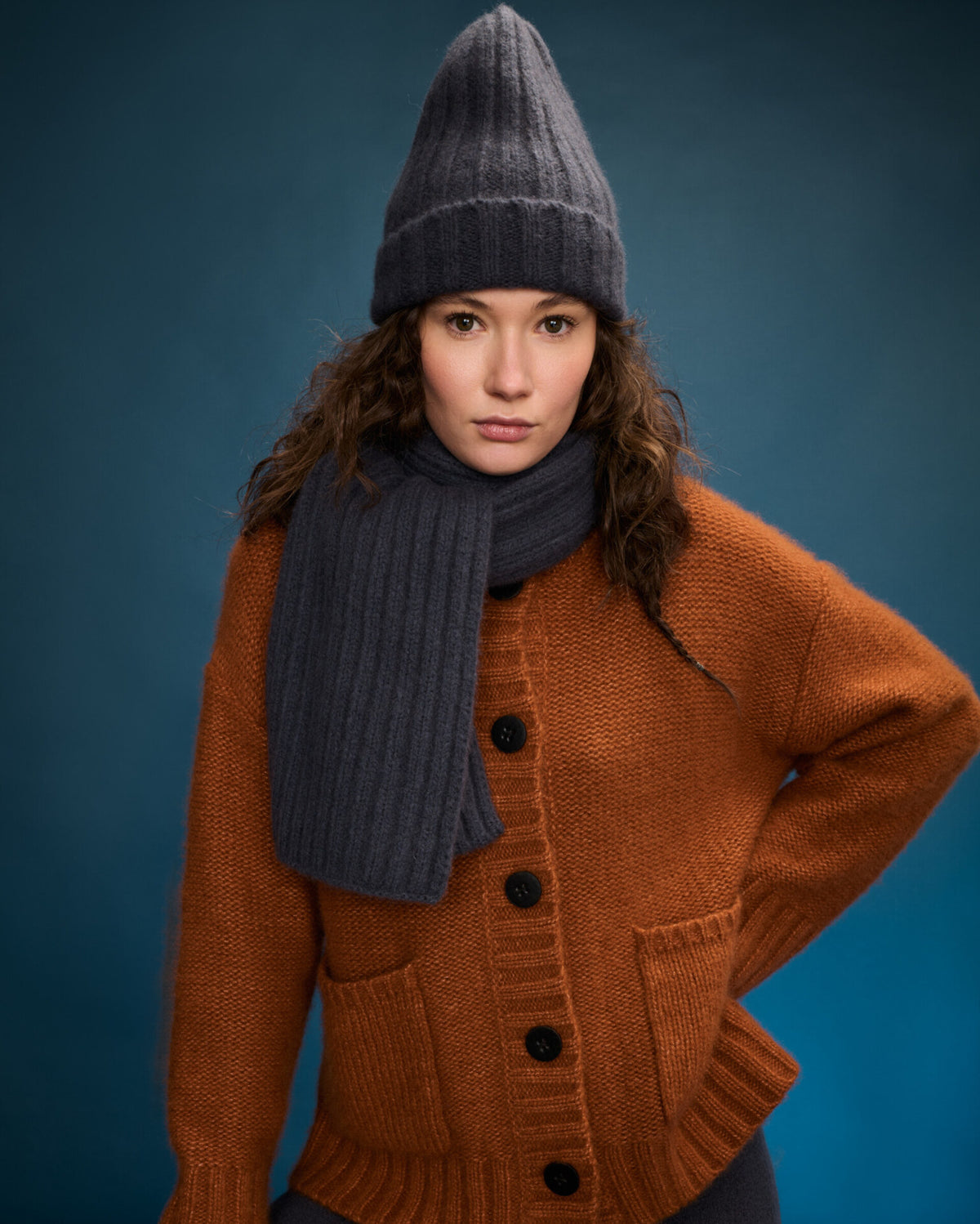 Damen Cardigan aus 75% Kaschmir, 25% Seide in Bronze – Cardigan mit hohem Stehkragen in Rippstruktur, waschbaren Lederknöpfen, zwei Eingrifftaschen an der Vorderseite, überschnittenen Schultern und langen, relaxten Ärmeln sowie Ärmelbündchen und Saum in Rippstruktur.