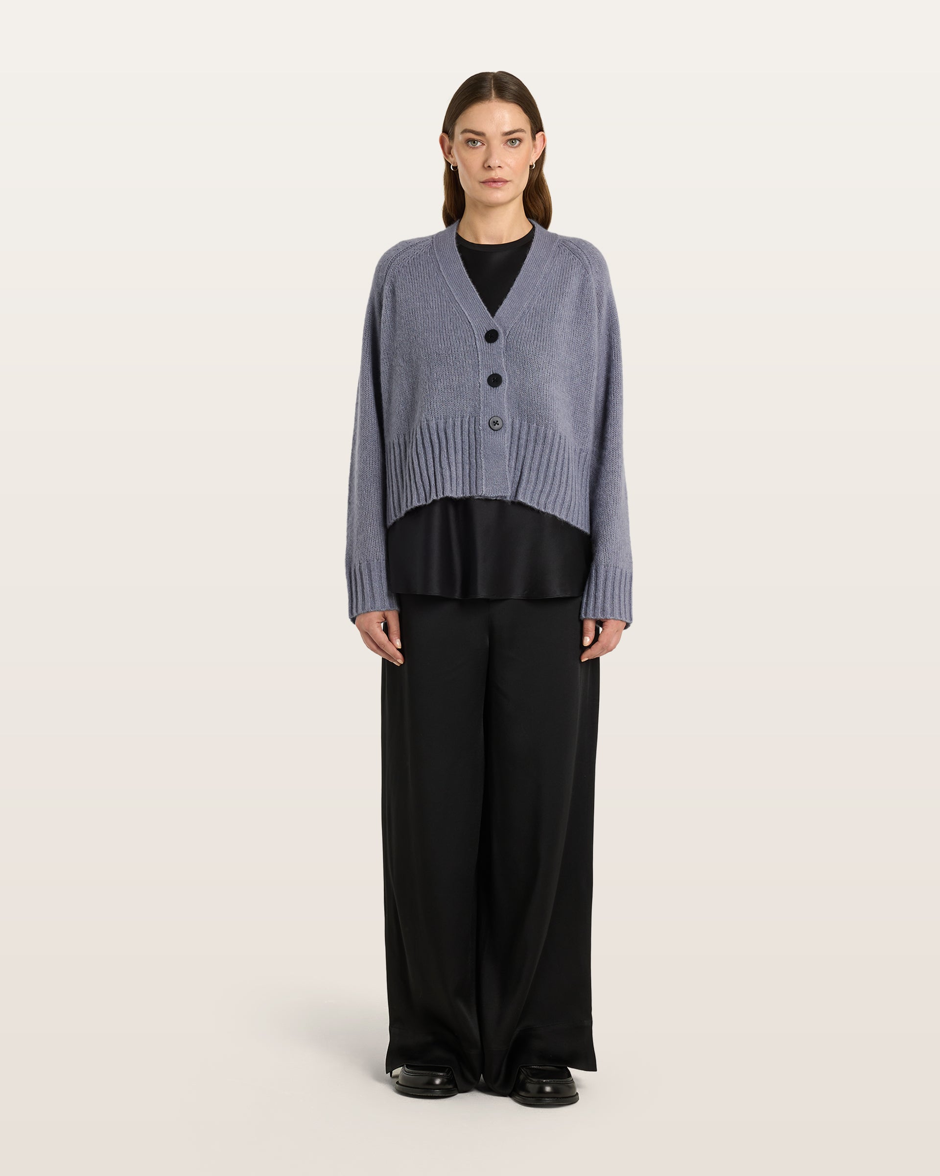 Damen Cardigan aus 75 % Kaschmir und 25 % Seide in Blue Mirage – glatt gestrickter Cardigan in mittelschwerer Qualität mit oversized Form in breiter, kurzer Silhouette. Das Modell verfügt über Raglanärmel, lange, relaxte Ärmel sowie Knöpfe aus waschbarem Leder. Saum und Ärmelbündchen sind in Rippstruktur gearbeitet und verleihen dem Cardigan einen modernen, lässigen Look.