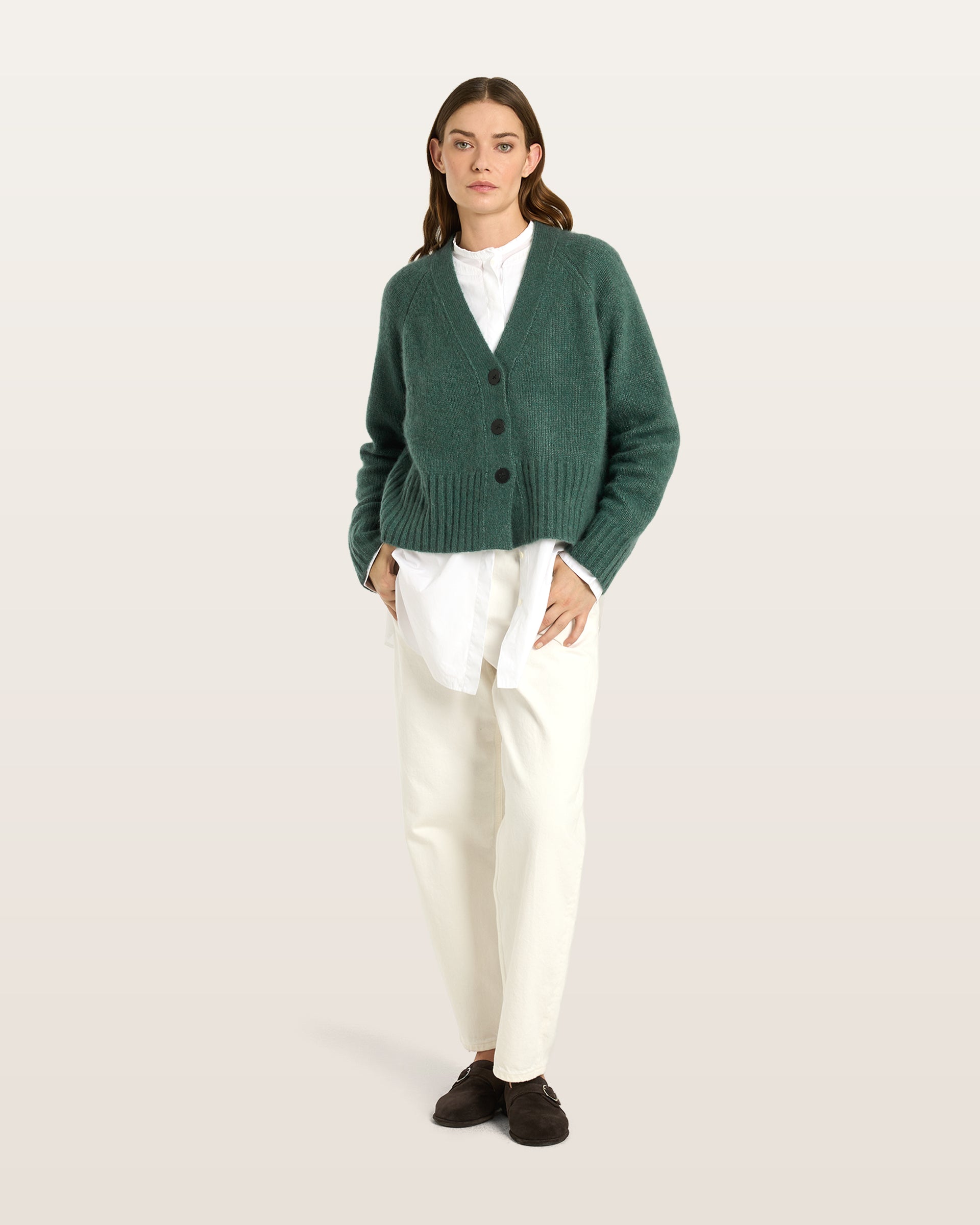 Damen Cardigan aus 75 % Kaschmir und 25 % Seide in Emerald – glatt gestrickter Cardigan in mittelschwerer Qualität mit oversized Form in breiter, kurzer Silhouette. Das Modell verfügt über Raglanärmel, lange, relaxte Ärmel sowie Knöpfe aus waschbarem Leder. Saum und Ärmelbündchen sind in Rippstruktur gearbeitet und verleihen dem Cardigan einen modernen, lässigen Look.