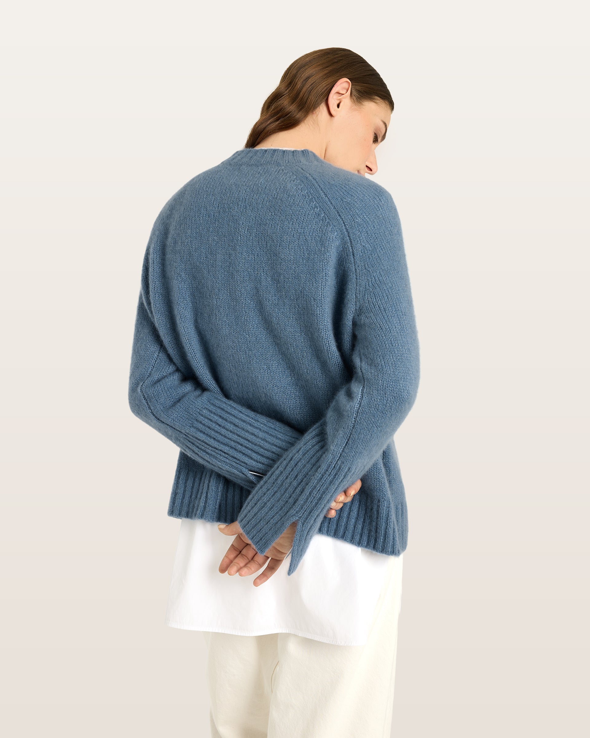 Damen Pullover aus 75 % Kaschmir und 25 % Seide in Blue Fog – glatt gestrickter Pullover in mittelschwerer Qualität mit kastiger, lockerer Passform, Rundhalsausschnitt mit Kragen in Rippstruktur, Raglanärmeln sowie langen, geraden Ärmeln mit Schlitz am Bündchen. Ärmelbündchen und Saum sind in Rippstruktur gearbeitet und verleihen dem Modell einen modernen, entspannten Look.
