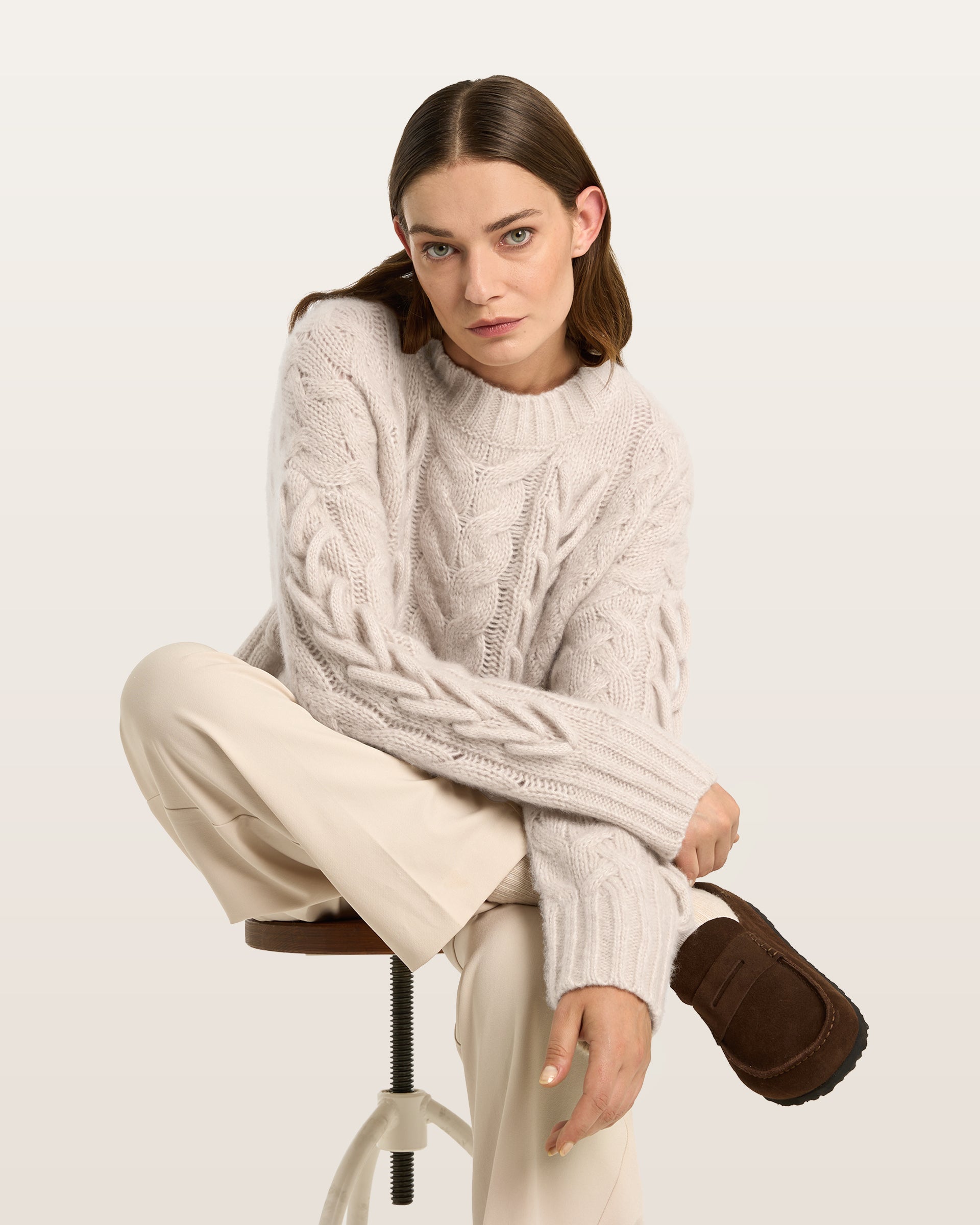 Damen Pullover aus 75 % Kaschmir und 25 % Seide in Wheat – Pullover mit Zopfstrickmuster und zusätzlich applizierten 3D-Zöpfen in grober Strickqualität mit relaxter Passform, Rundhalsausschnitt mit Kragen in Rippstruktur, überschnittener Schulter sowie langen, relaxten Ärmeln. Ärmelbündchen und Saum sind in Rippstruktur gearbeitet und unterstreichen den markanten, handwerklichen Charakter des Designs.
