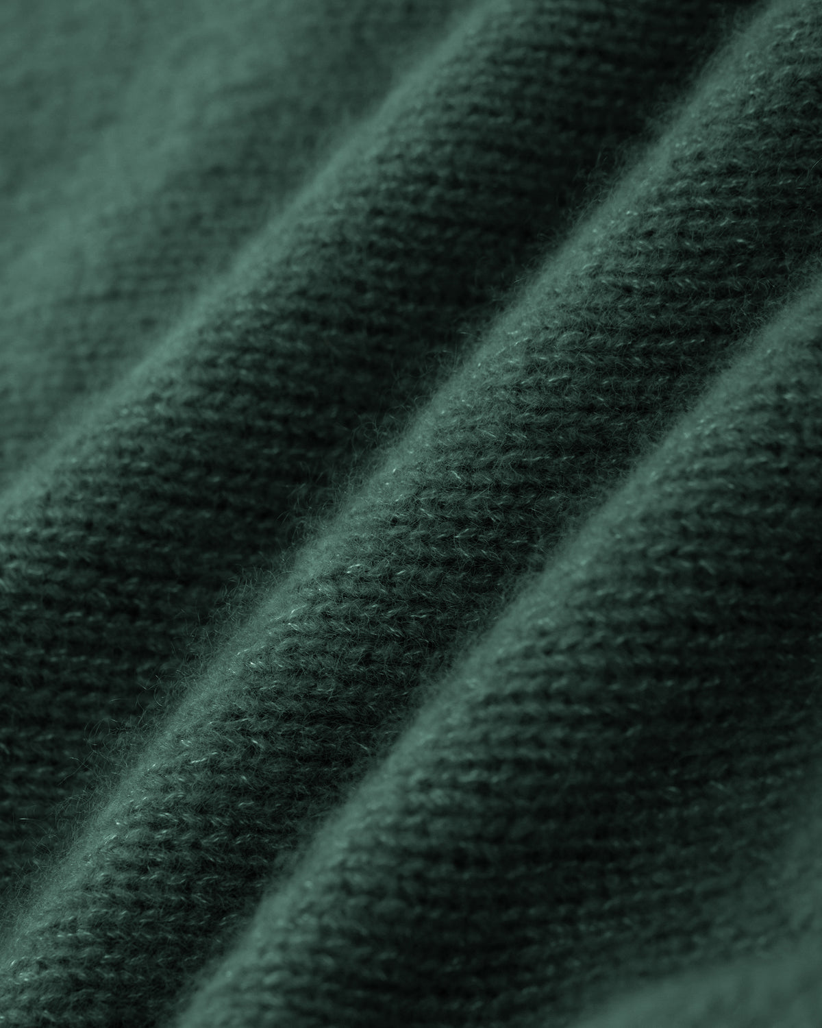 Damen Pullover aus 75 % Kaschmir und 25 % Seide in Emerald – glatt gestrickter Pullover in mittelschwerer Qualität mit lockerer Passform, V-Ausschnitt mit breitem Kragen in Rippstruktur, Sattelschulter sowie langen, schmalen Ärmeln. Ärmelbündchen und Saum sind in Rippstruktur gearbeitet, ein besonderes Design-Detail am Saum rundet das Modell ab.