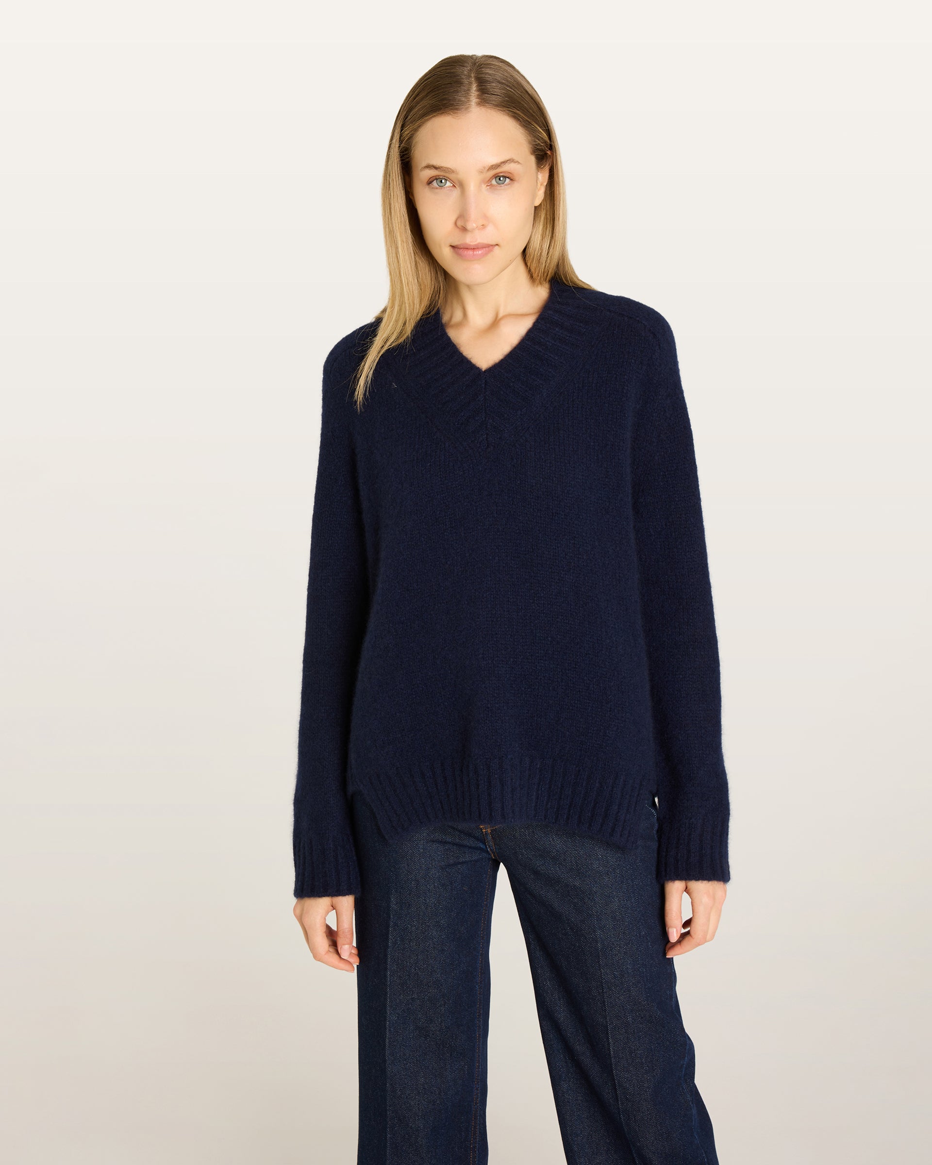 Damen Pullover aus 75 % Kaschmir und 25 % Seide in French Navy – glatt gestrickter Pullover in mittelschwerer Qualität mit lockerer Passform, V-Ausschnitt mit breitem Kragen in Rippstruktur, Sattelschulter sowie langen, schmalen Ärmeln. Ärmelbündchen und Saum sind in Rippstruktur gearbeitet, ein besonderes Design-Detail am Saum rundet das Modell ab.
