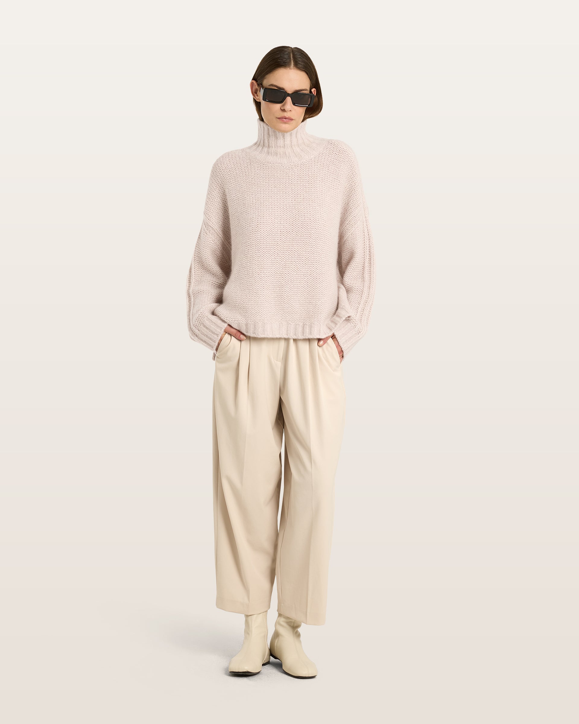Damen Pullover aus 75 % Kaschmir und 25 % Seide in Wheat – links gestrickter Pullover in grober Strickqualität mit oversized Passform. Der Rollkragen in Rippstruktur, überschnittene Schultern und lange, relaxte Ärmel verleihen dem Modell eine lässige Silhouette. Rippstrukturen an Seitennähten, Schultern und Ärmeln setzen besondere Akzente, während das verlängerte Rückenteil und seitliche Schlitze den modernen Look abrunden.