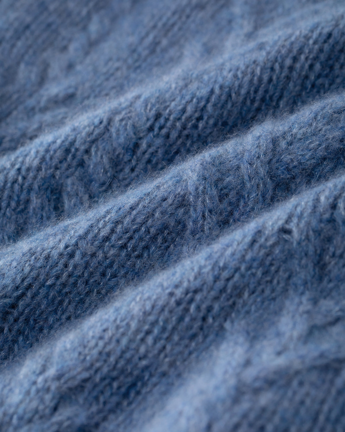 Damen Pullover aus 75 % Kaschmir und 25 % Seide in Denim – Pullover mit klassischem Zopfmuster in mittelschwerer Qualität und figurbetonter A-Linien-Silhouette. Der schmale, hohe Kragen mit Rollkante sowie die langen, ausgestellten Ärmel verleihen dem Modell eine feminine und elegante Ausstrahlung.