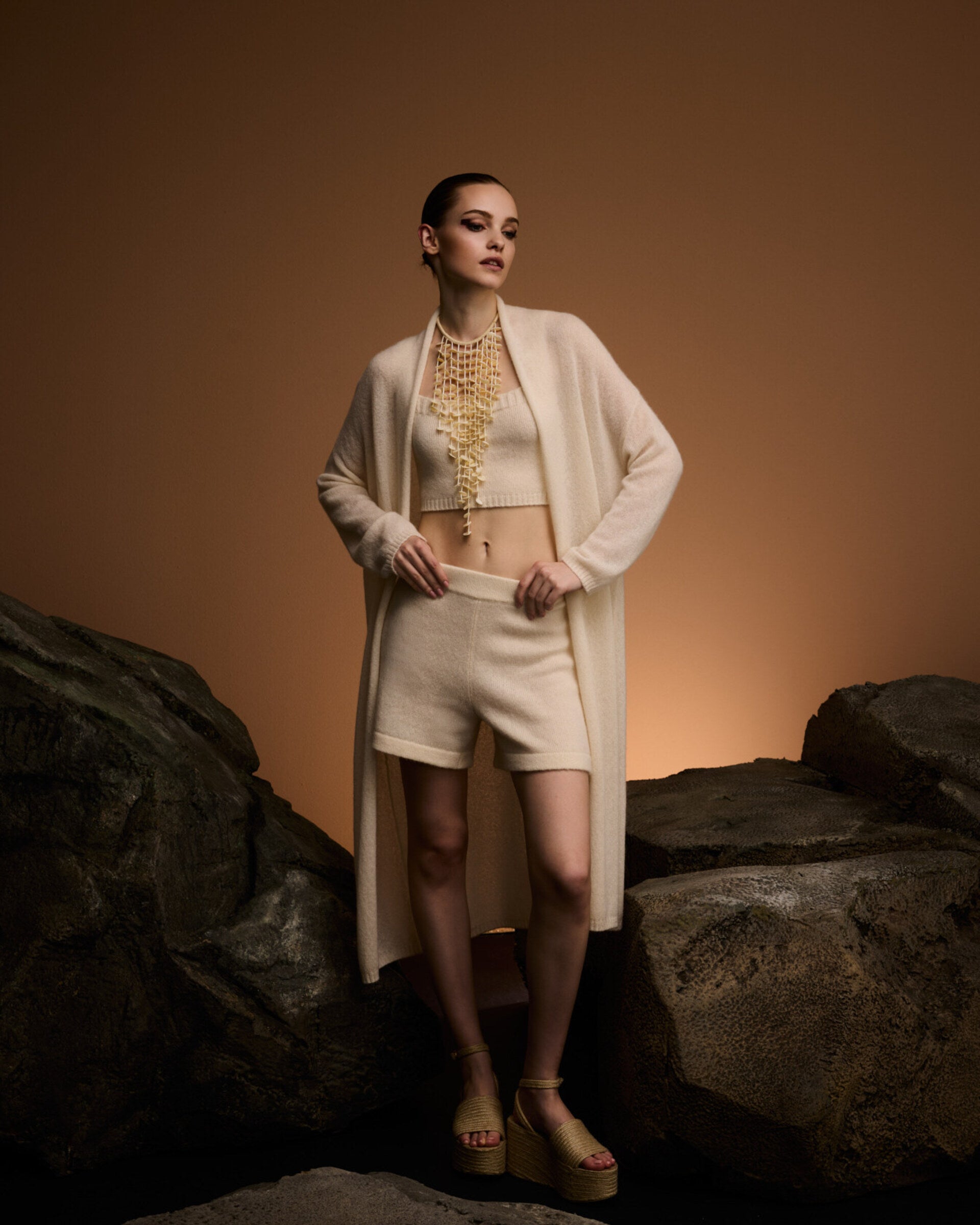 Damen Strickmantel in ivory (cremeweiß) aus Kaschmir-Seide – glatt und leicht gestrickt, relaxte Passform, überschnittene Schultern, lange relaxte Ärmel mit Rippbündchen, Saum in Rippstruktur und langer Gürtel.