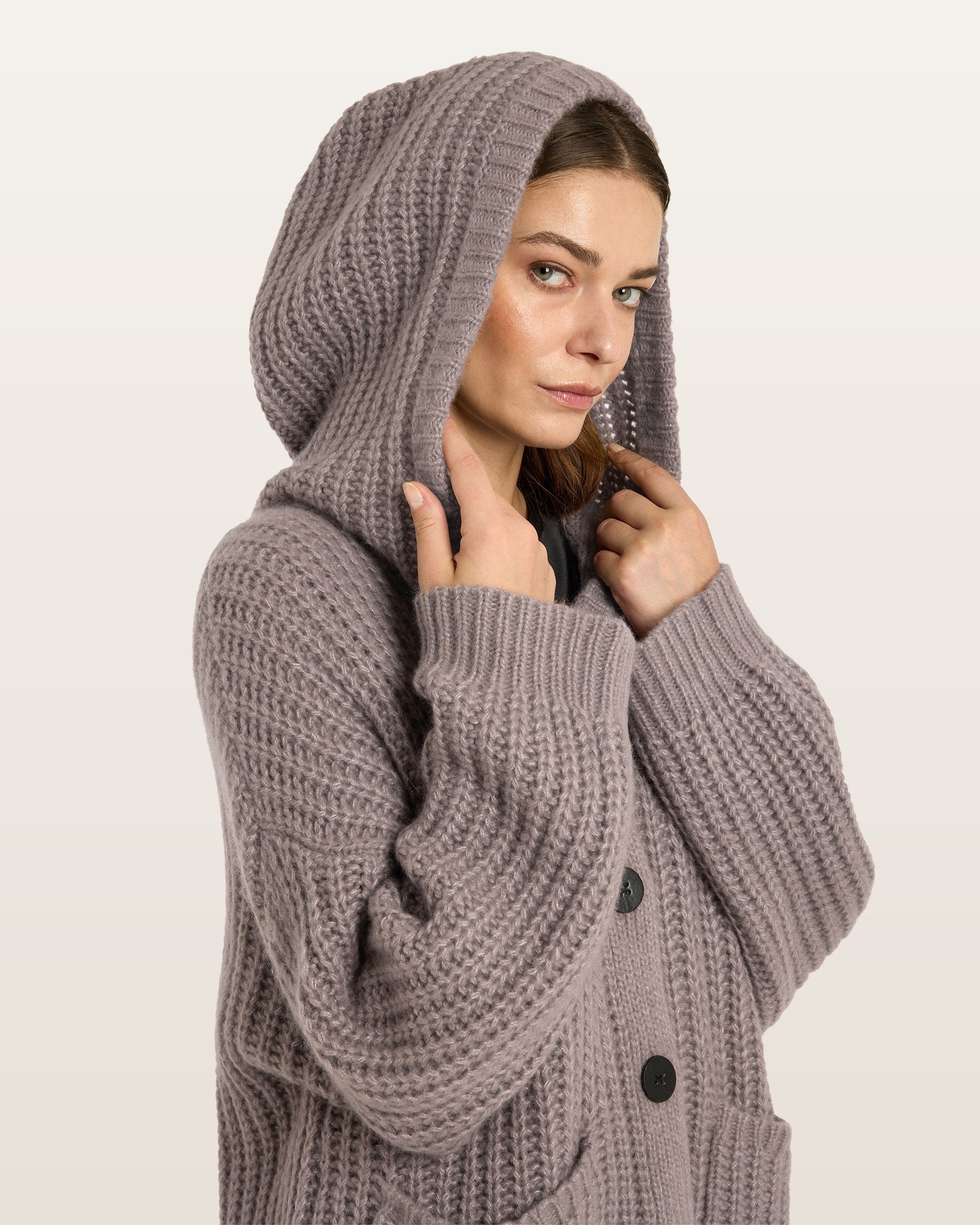 Damen Cardigan aus 75 % Kaschmir und 25 % Seide in Natural Twine – Cardigan im Halbpatent-Strickmuster in grober Strickqualität mit oversized Passform in großer, weiter und langer Silhouette. Das Modell verfügt über eine Knopfleiste mit Knöpfen aus waschbarem Leder, eine überschnittene Schulter sowie lange, weite Ärmel. Große aufgesetzte Taschen und eine Kapuze mit Abschluss in Rippstruktur verleihen dem Design einen lässigen Charakter. Ärmelbündchen und Saum sind in Rippstruktur gearbeitet.
