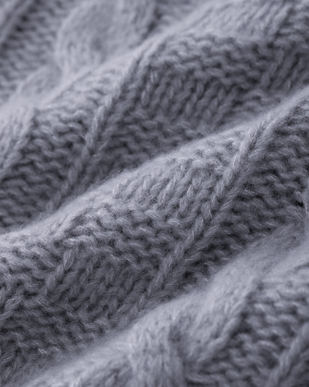 Damen Pullover aus 75 % Kaschmir und 25 % Seide in Blue Mirage – grob gestrickter Pullover mit Zopf- und Schachbrettmuster in oversized Passform, hohem Stehkragen in Rippstruktur, überschnittener Schulter sowie langen, relaxten Ärmeln. Ärmelbündchen und Saum sind in Rippstruktur gearbeitet und unterstreichen den markanten Strickcharakter des Modells.