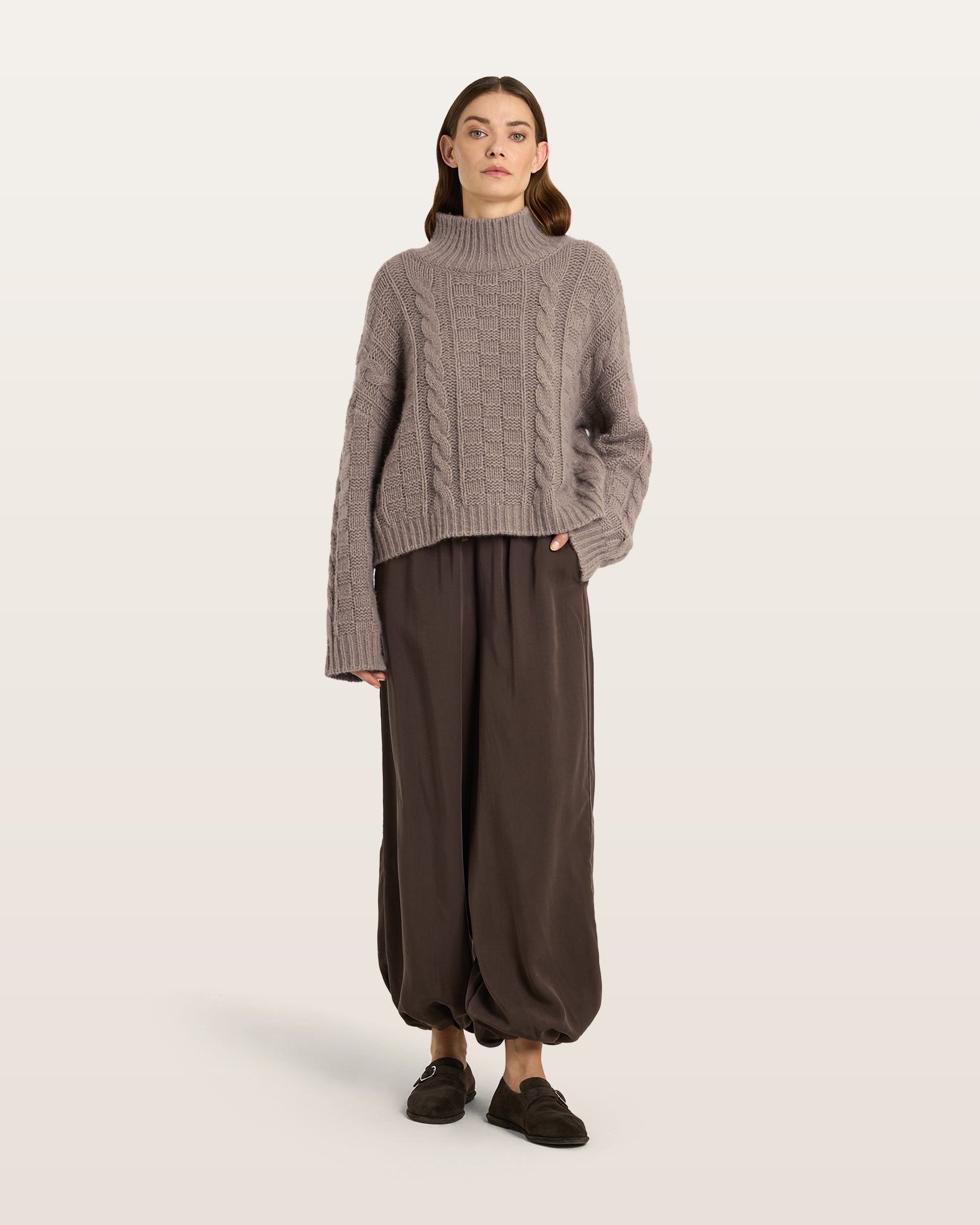 Damen Pullover aus 75 % Kaschmir und 25 % Seide in Natural Twine – grob gestrickter Pullover mit Zopf- und Schachbrettmuster in oversized Passform, hohem Stehkragen in Rippstruktur, überschnittener Schulter sowie langen, relaxten Ärmeln. Ärmelbündchen und Saum sind in Rippstruktur gearbeitet und unterstreichen den markanten Strickcharakter des Modells.
