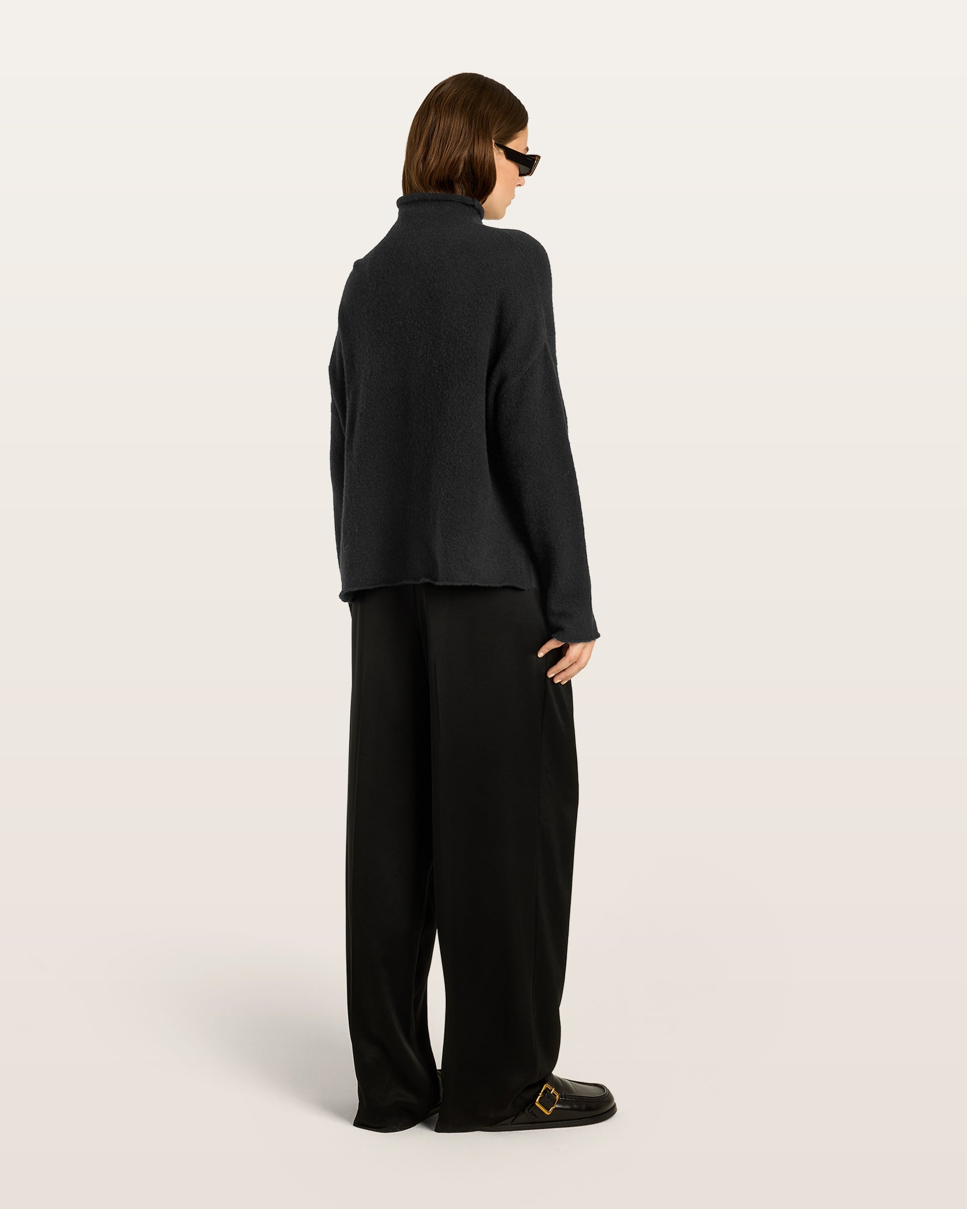 Damen Pullover aus 80 % Kaschmir, 18 % Polyamid und 2 % Elastan in Black – glatt gestrickter Pullover in mittelschwerer Qualität mit gefilzter, besonders elastischer Oberfläche und oversized Passform. Das Modell verfügt über einen Stehkragen, eine überschnittene Schulterform sowie lange, relaxte Ärmel. Das verlängerte Rückenteil mit Seitenschlitzen verleiht dem Pullover eine moderne, lässige Silhouette.