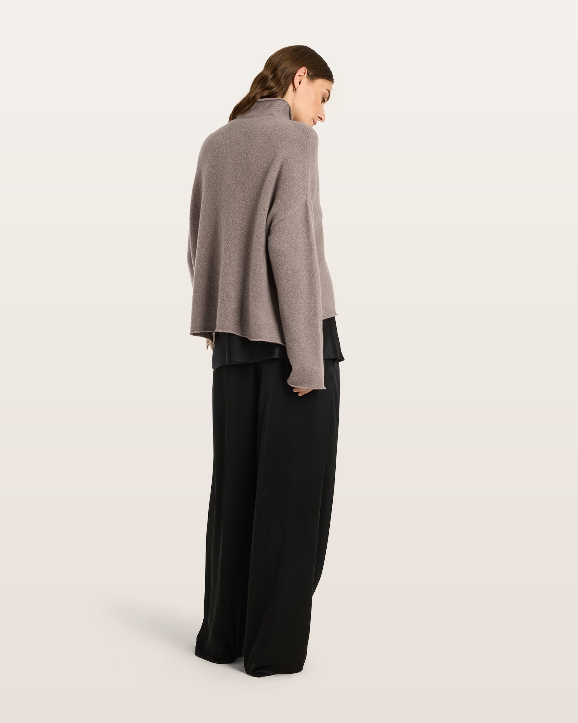 Damen Pullover aus 80 % Kaschmir, 18 % Polyamid und 2 % Elastan in Natural Twine – glatt gestrickter Pullover in mittelschwerer Qualität mit gefilzter, besonders elastischer Oberfläche und oversized Passform. Das Modell verfügt über einen Stehkragen, eine überschnittene Schulterform sowie lange, relaxte Ärmel. Das verlängerte Rückenteil mit Seitenschlitzen verleiht dem Pullover eine moderne, lässige Silhouette.

