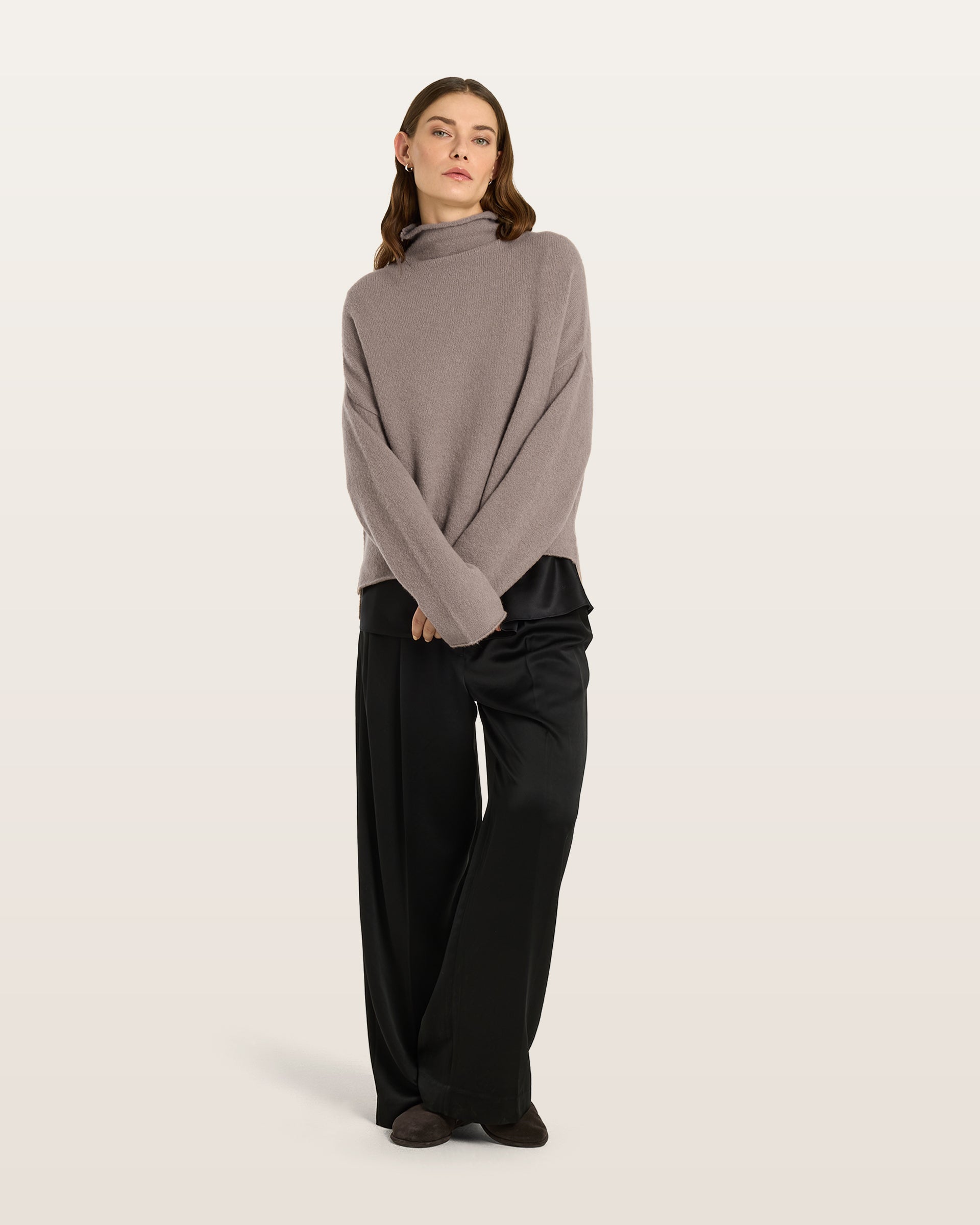 Damen Pullover aus 80 % Kaschmir, 18 % Polyamid und 2 % Elastan in Natural Twine – glatt gestrickter Pullover in mittelschwerer Qualität mit gefilzter, besonders elastischer Oberfläche und oversized Passform. Das Modell verfügt über einen Stehkragen, eine überschnittene Schulterform sowie lange, relaxte Ärmel. Das verlängerte Rückenteil mit Seitenschlitzen verleiht dem Pullover eine moderne, lässige Silhouette.
