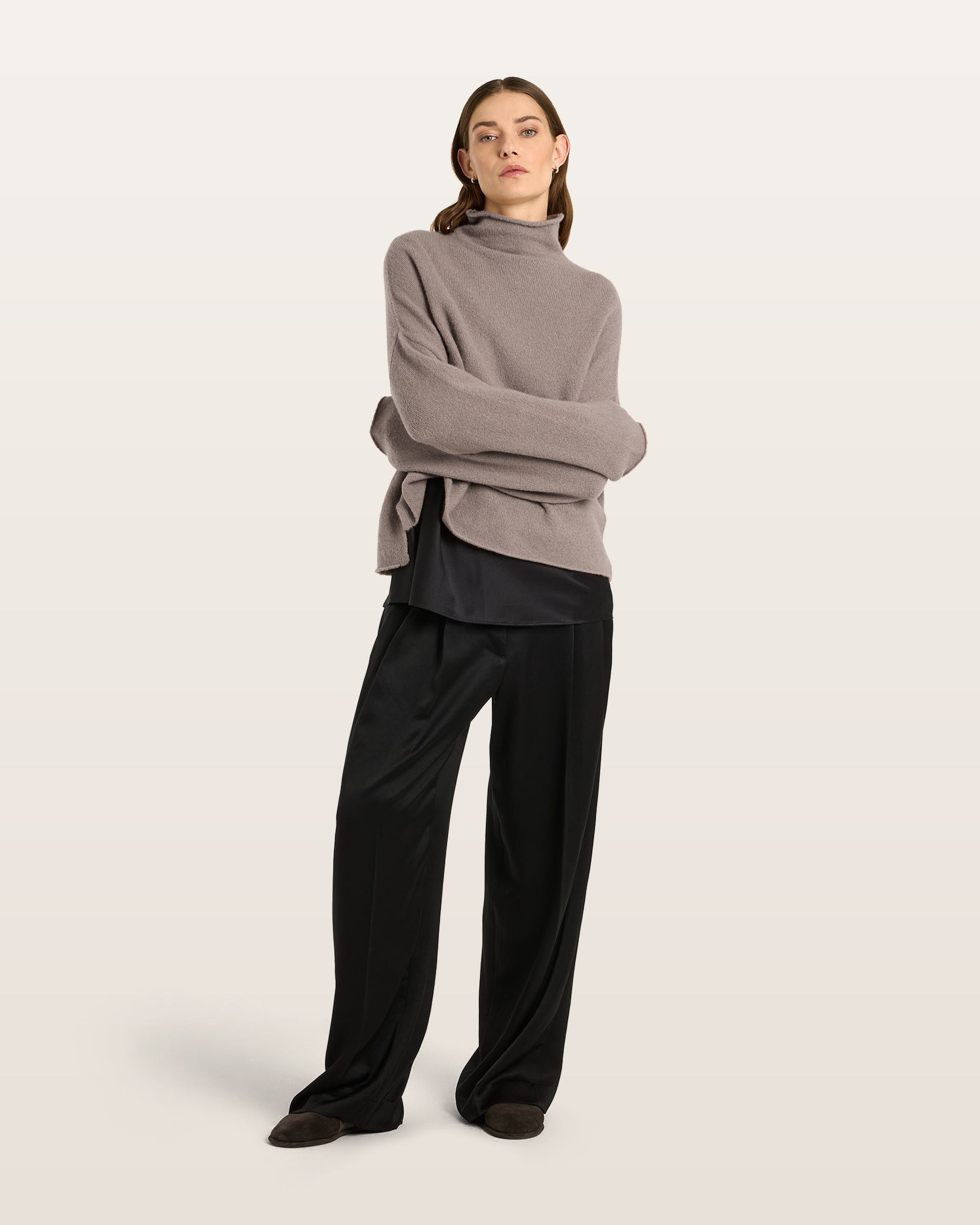 Damen Pullover aus 80 % Kaschmir, 18 % Polyamid und 2 % Elastan in Natural Twine – glatt gestrickter Pullover in mittelschwerer Qualität mit gefilzter, besonders elastischer Oberfläche und oversized Passform. Das Modell verfügt über einen Stehkragen, eine überschnittene Schulterform sowie lange, relaxte Ärmel. Das verlängerte Rückenteil mit Seitenschlitzen verleiht dem Pullover eine moderne, lässige Silhouette.
