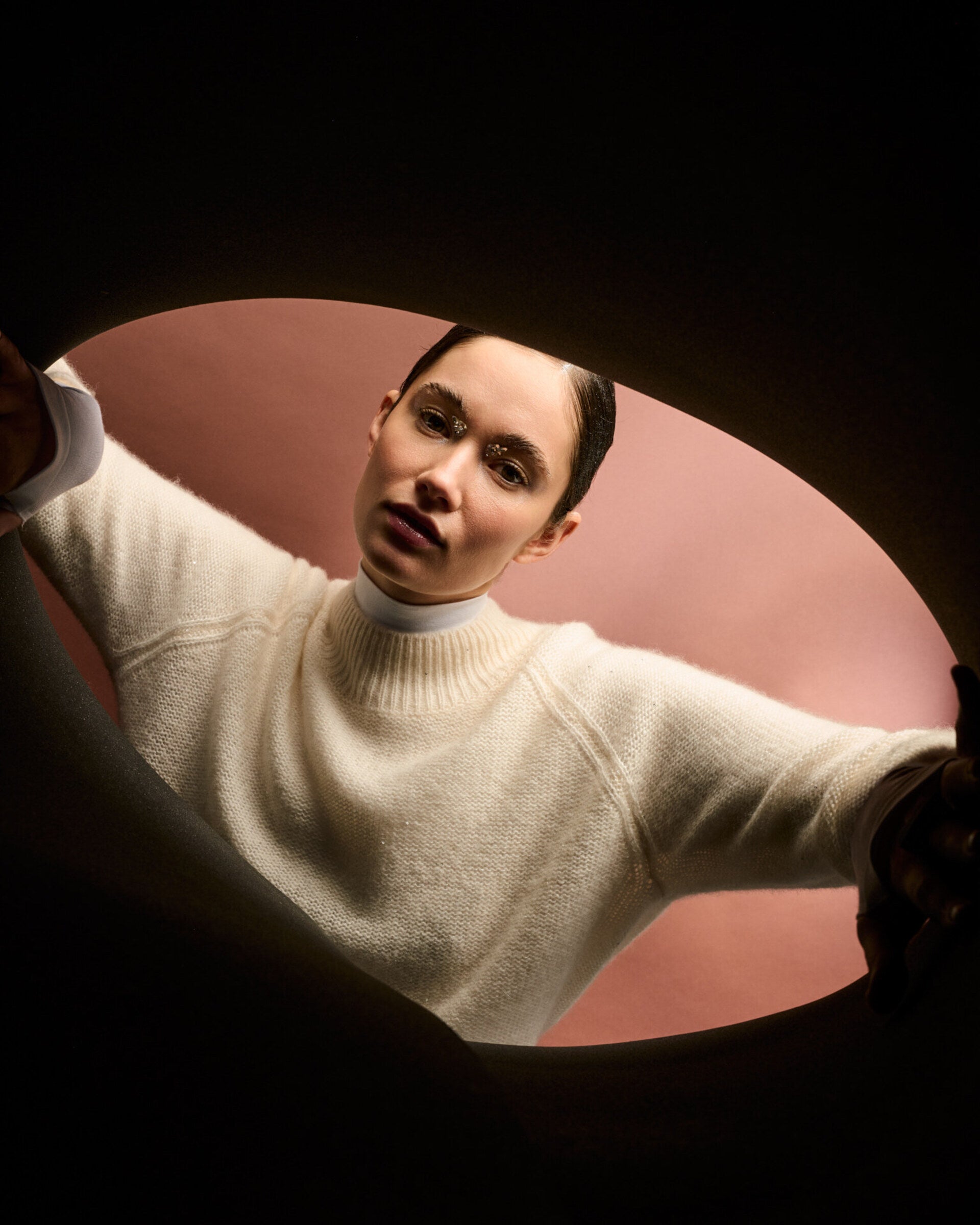 Damen Pullover aus 60 % Kaschmir, 39 % Seide und 1 % Pailletten in Ivory – links gestrickter Pullover in mittelschwerer Qualität mit lockerer Passform und geradem Schnitt. Das lange Modell verfügt über einen Rundhalsausschnitt mit hohem Kragen in Rippstruktur, Raglanärmel sowie lange, relaxte Ärmel. Ärmelbündchen und Saum sind in Rippstruktur gearbeitet. Schlitze an den Seitennähten und dezent eingearbeitete Pailletten verleihen dem Pullover eine moderne, elegante Ausstrahlung.

