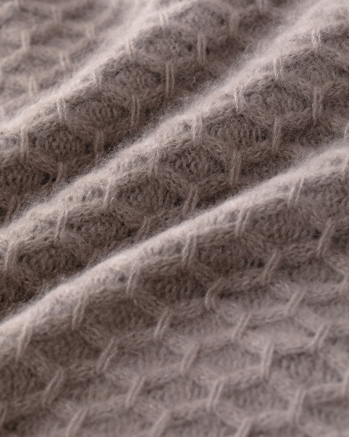 Damen Pullover aus 75 % Kaschmir und 25 % Seide in Natural Twine – Pullover mit grafischem Zopfstrickmuster in grober Strickqualität und oversized Passform mit breiter, kurzer, gerade geschnittener Silhouette. Das Modell verfügt über einen Rundhalsausschnitt mit Kragen in Rippstruktur, Raglanärmel sowie lange, relaxte Ärmel. Hohe Ärmelbündchen und Saum sind in Rippstruktur gearbeitet und verleihen dem Design einen markanten, modernen Look.
