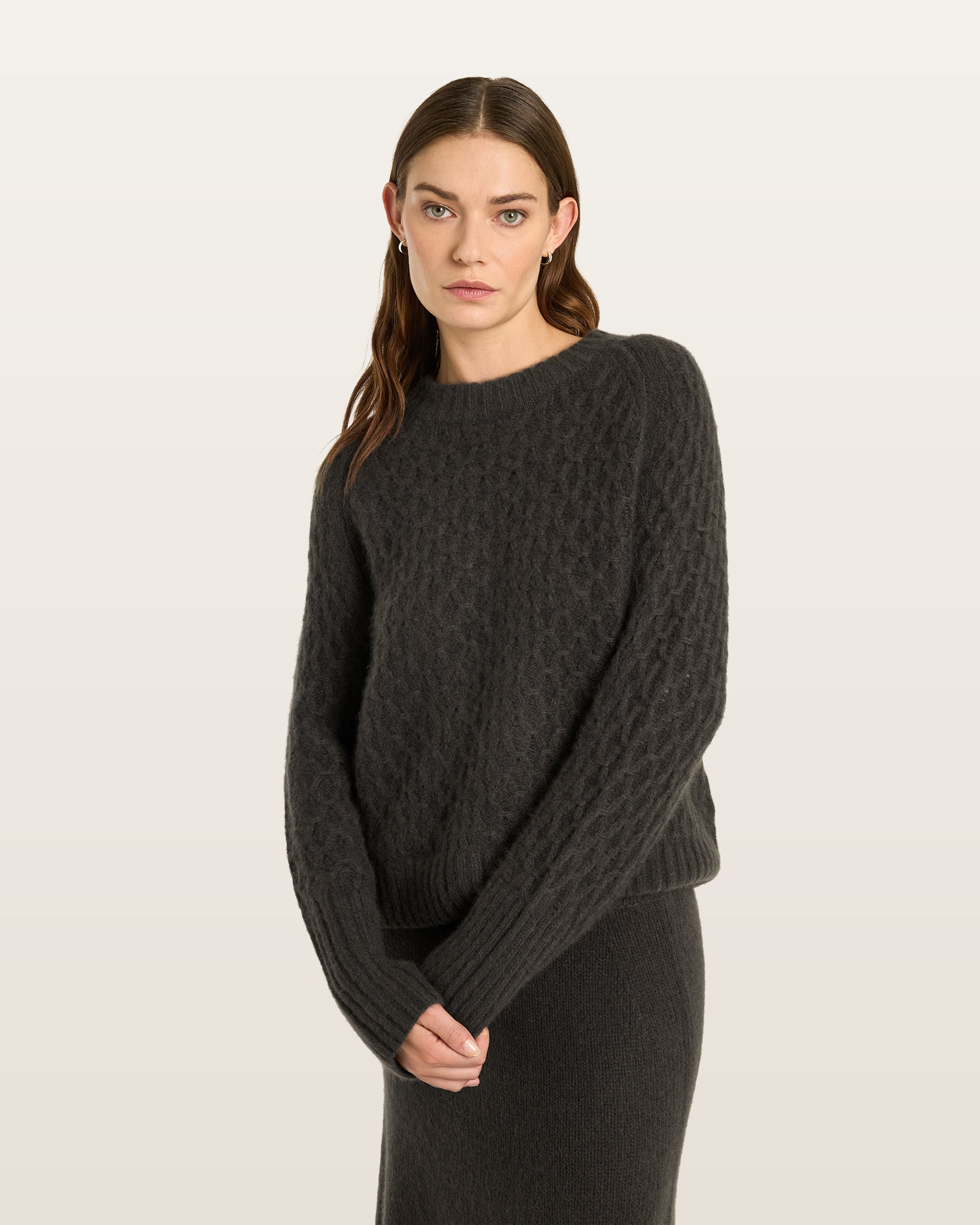 Damen Pullover aus 75 % Kaschmir und 25 % Seide in Black Forest – Pullover mit grafischem Zopfstrickmuster in grober Strickqualität und oversized Passform mit breiter, kurzer, gerade geschnittener Silhouette. Das Modell verfügt über einen Rundhalsausschnitt mit Kragen in Rippstruktur, Raglanärmel sowie lange, relaxte Ärmel. Hohe Ärmelbündchen und Saum sind in Rippstruktur gearbeitet und verleihen dem Design einen markanten, modernen Look.
