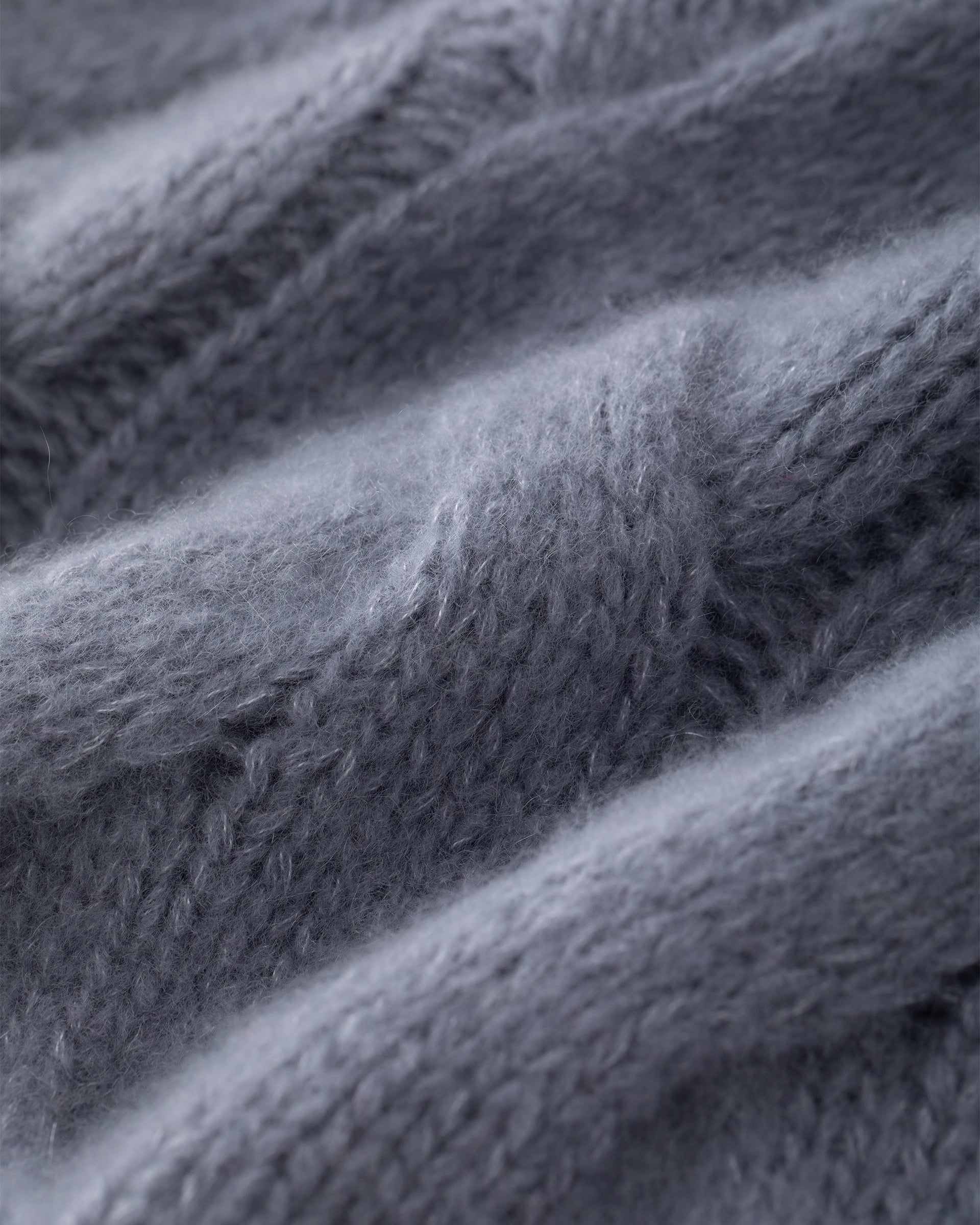 Damen Pullover aus 75 % Kaschmir und 25 % Seide in Blue Mirage – grob gestrickter Pullover mit Zopfstrickmuster in oversized Passform mit langer, weiter Silhouette. Das Modell verfügt über einen hohen Stehkragen in Rippstruktur, eine überschnittene Schulter sowie lange, weite Ärmel. Ärmelbündchen und Saum sind in Rippstruktur gearbeitet und unterstreichen den markanten Strickcharakter des Designs.
