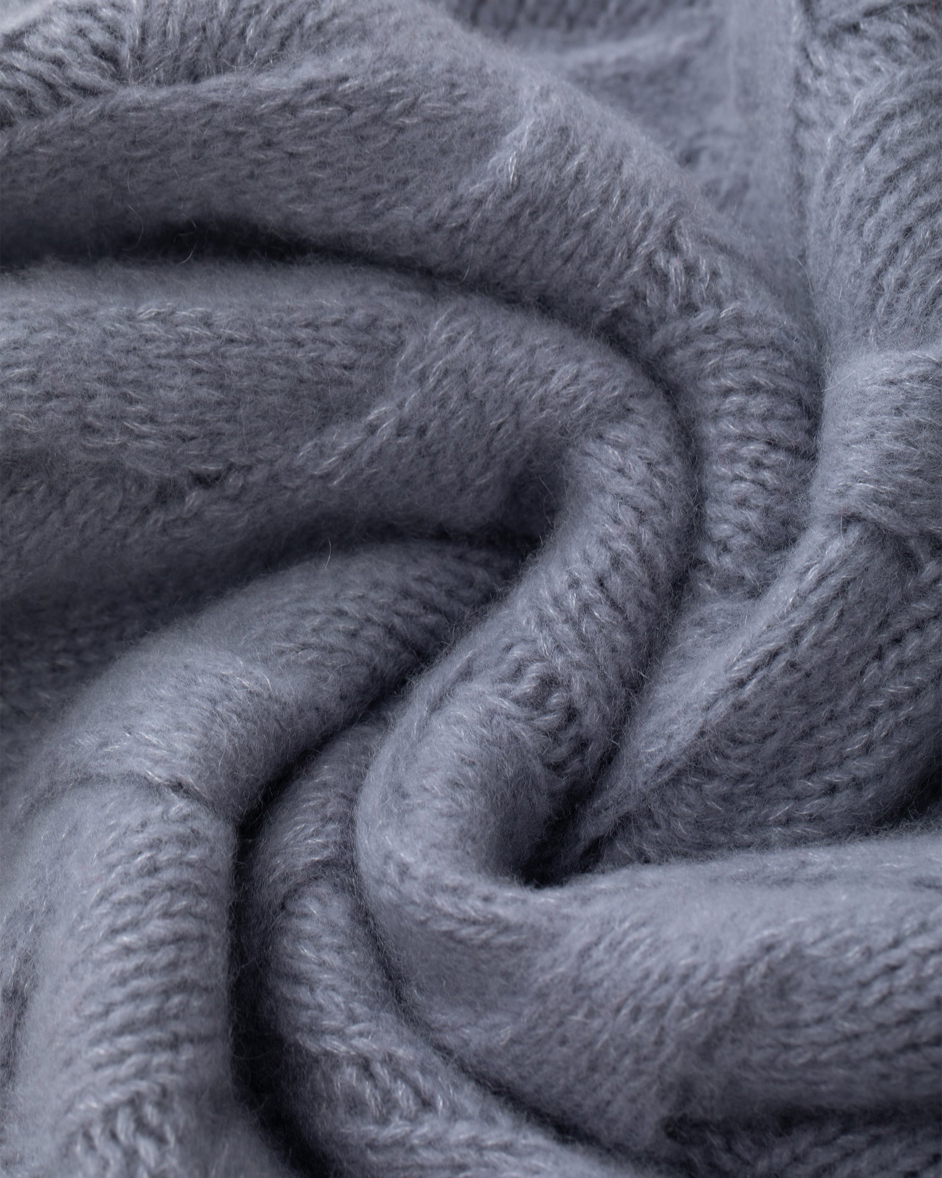 Damen Pullover aus 75 % Kaschmir und 25 % Seide in Blue Mirage – grob gestrickter Pullover mit Zopfstrickmuster in oversized Passform mit langer, weiter Silhouette. Das Modell verfügt über einen hohen Stehkragen in Rippstruktur, eine überschnittene Schulter sowie lange, weite Ärmel. Ärmelbündchen und Saum sind in Rippstruktur gearbeitet und unterstreichen den markanten Strickcharakter des Designs.
