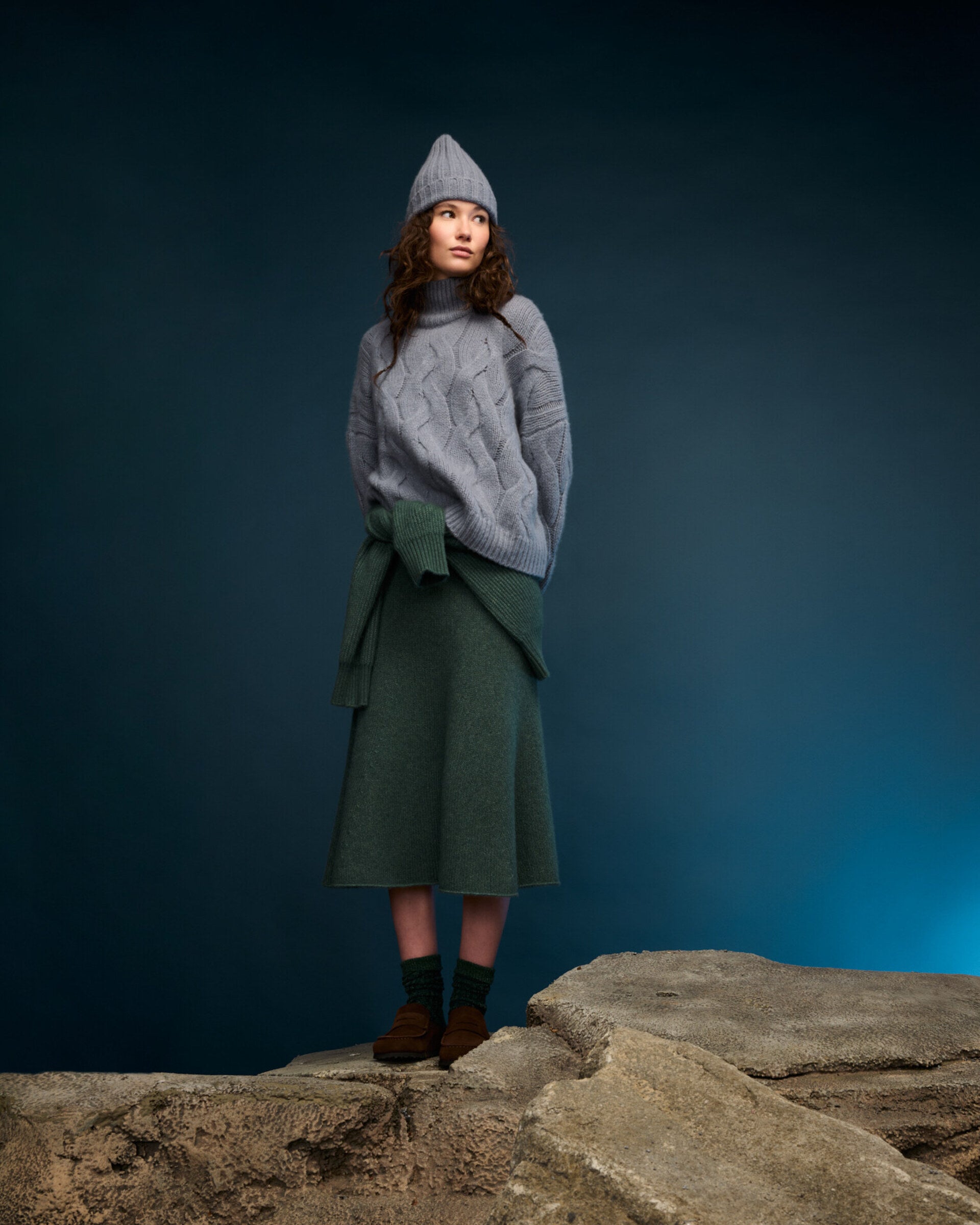 Damen Pullover aus 75 % Kaschmir und 25 % Seide in Blue Mirage – grob gestrickter Pullover mit Zopfstrickmuster in oversized Passform mit langer, weiter Silhouette. Das Modell verfügt über einen hohen Stehkragen in Rippstruktur, eine überschnittene Schulter sowie lange, weite Ärmel. Ärmelbündchen und Saum sind in Rippstruktur gearbeitet und unterstreichen den markanten Strickcharakter des Designs.
